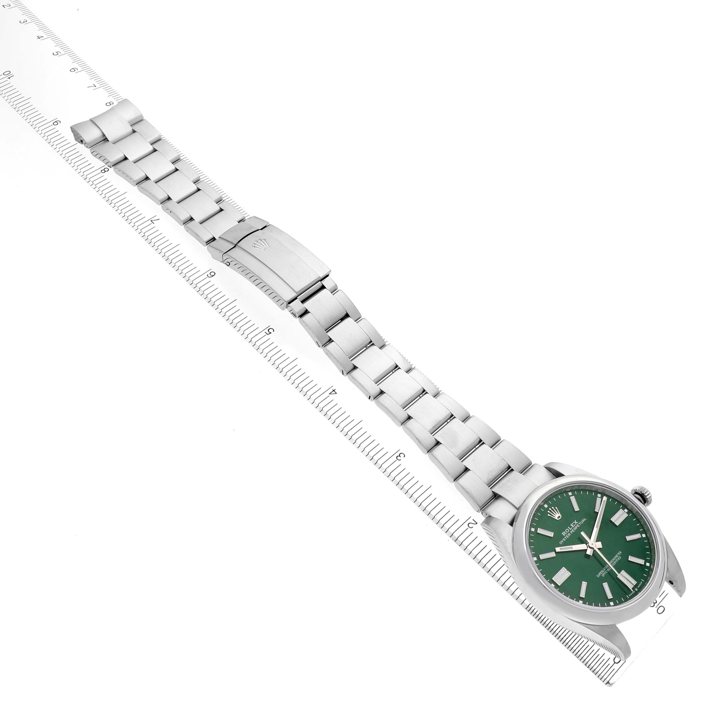 The Rolex Oyster Perpetual 124300 Men's Stainless Steel Green Dial 124300 Men's Stainless Steel Green Dial watch is shown from a top-down angle, displaying the green dial, metal bracelet, and clasp.