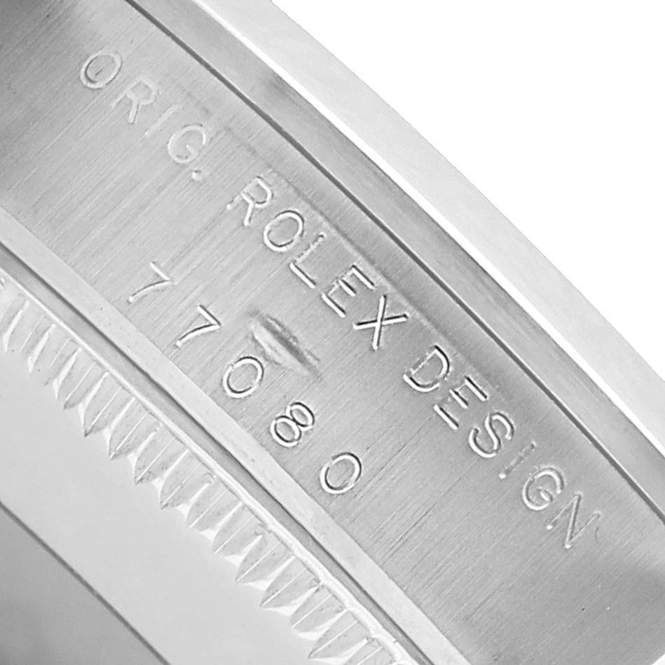The image shows a close-up of the inner bezel of the Rolex Oyster Perpetual 77080 Women's Stainless Steel Silver Dial, featuring the model number and brand engraving.