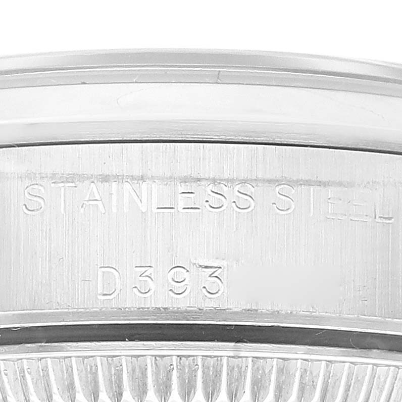 The image shows a close-up of the case back of a Rolex Oyster Perpetual 76080 Women's Stainless Steel Orange Dial 76080 Women's Stainless Steel Orange Dial watch, highlighting the stainless steel engraving.