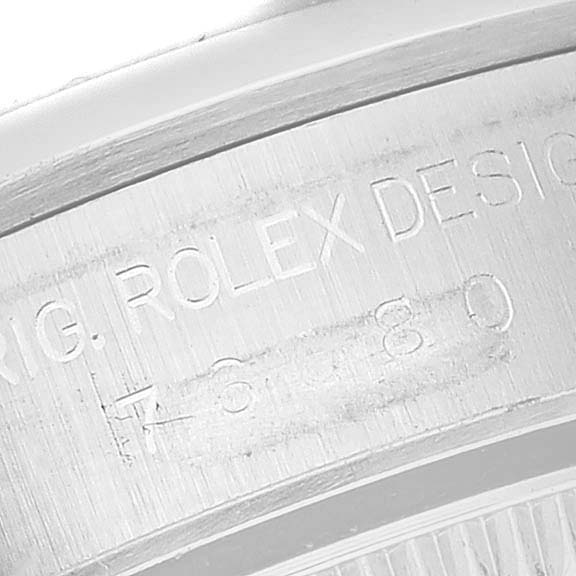 This image shows a close-up of the engraved bezel on a Rolex Oyster Perpetual 76080 Women's Stainless Steel Orange Dial 76080 Women's Stainless Steel Orange Dial watch.