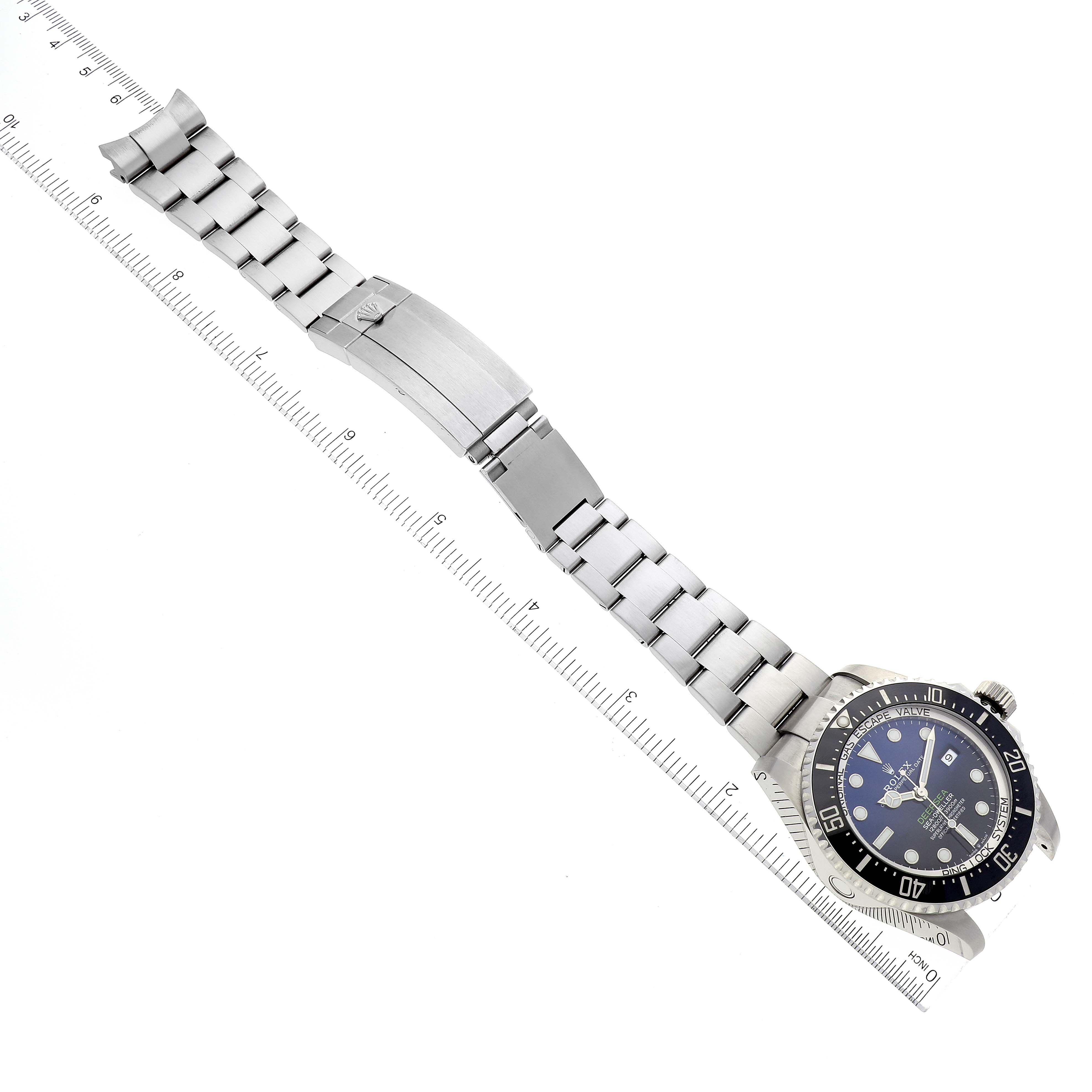 The image shows a top-down angle of the Rolex Sea-Dweller 126660 Men's Stainless Steel Blue Dial 126660 Men's Stainless Steel Blue Dial watch, highlighting its full bracelet and clasp along a ruler for scale.