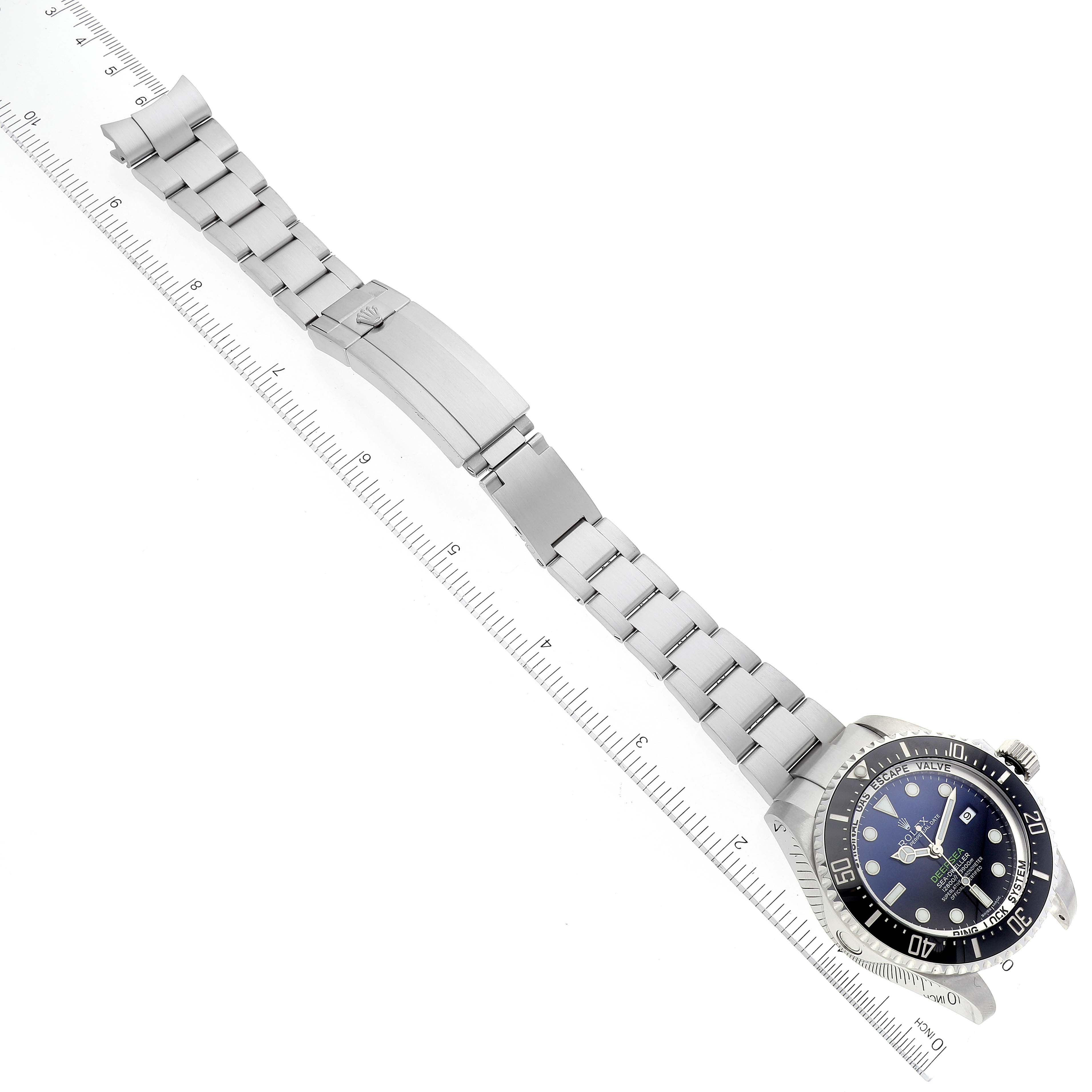 The image displays a Rolex Sea-Dweller 116660 Men's Stainless Steel Blue Dial 116660 Men's Stainless Steel Blue Dial watch laid flat with its bracelet extended next to a ruler for scale.