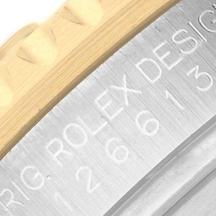 The image shows a close-up of the Rolex Submariner 126613LB Men's Steel and Gold (two tone) Blue Dial 126613LB Men's Steel and Gold (two tone) Blue Dial's engraved case edge and bezel teeth.