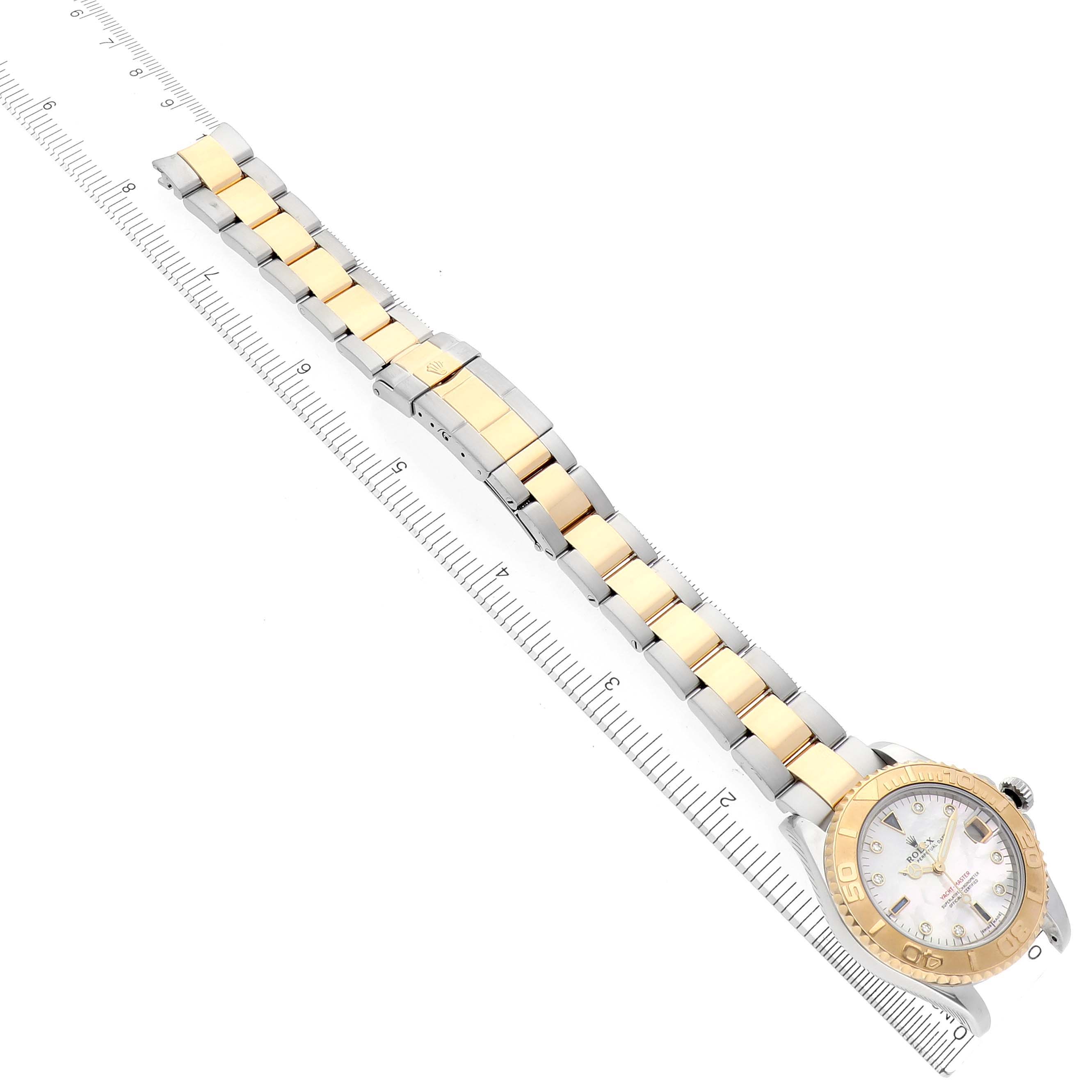 The Rolex Yacht-Master 168623 Men's Steel and Gold (two tone) Mother of Pearl Dial 168623 Men's Steel and Gold (two tone) Mother of Pearl Dial watch is shown from a top-down angle, highlighting the gold and silver bracelet and the face with a ruler alongside.