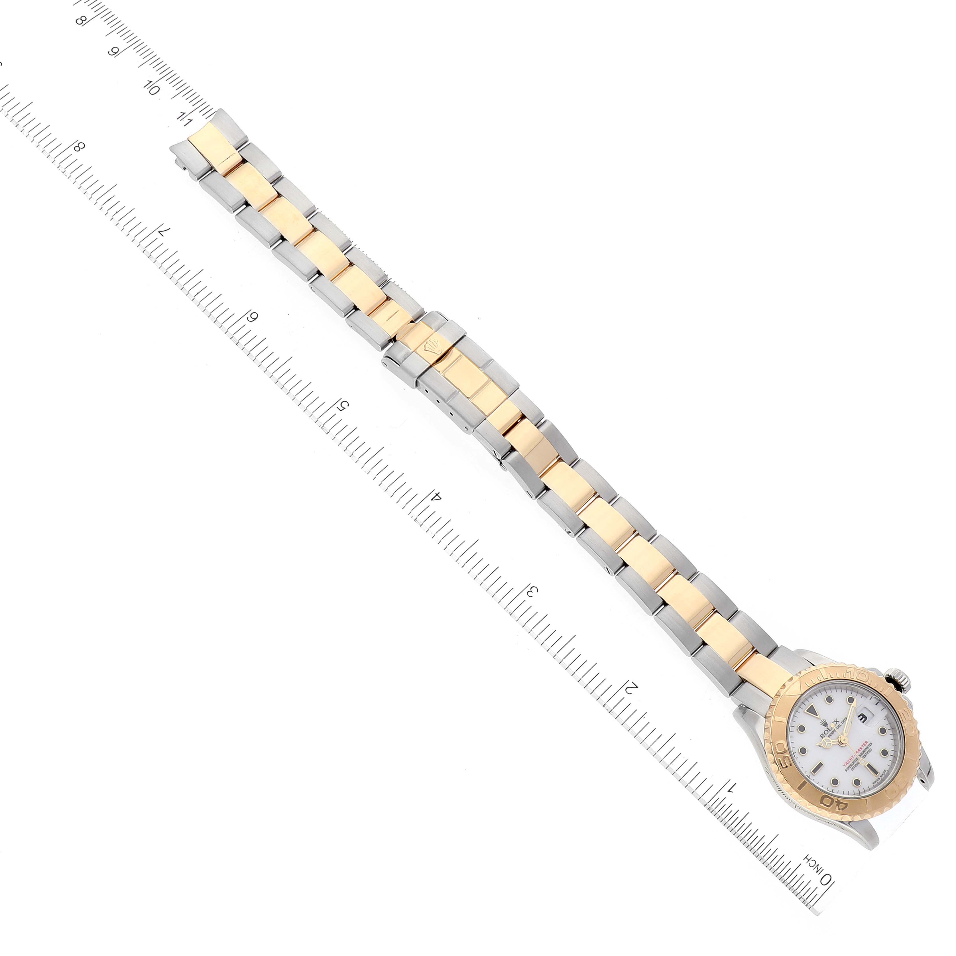 This top-down view shows the full length of a Rolex Yacht-Master 169623 Women's Steel and Gold (two tone) White Dial 169623 Women's Steel and Gold (two tone) White Dial watch with its bracelet aligned with a ruler.