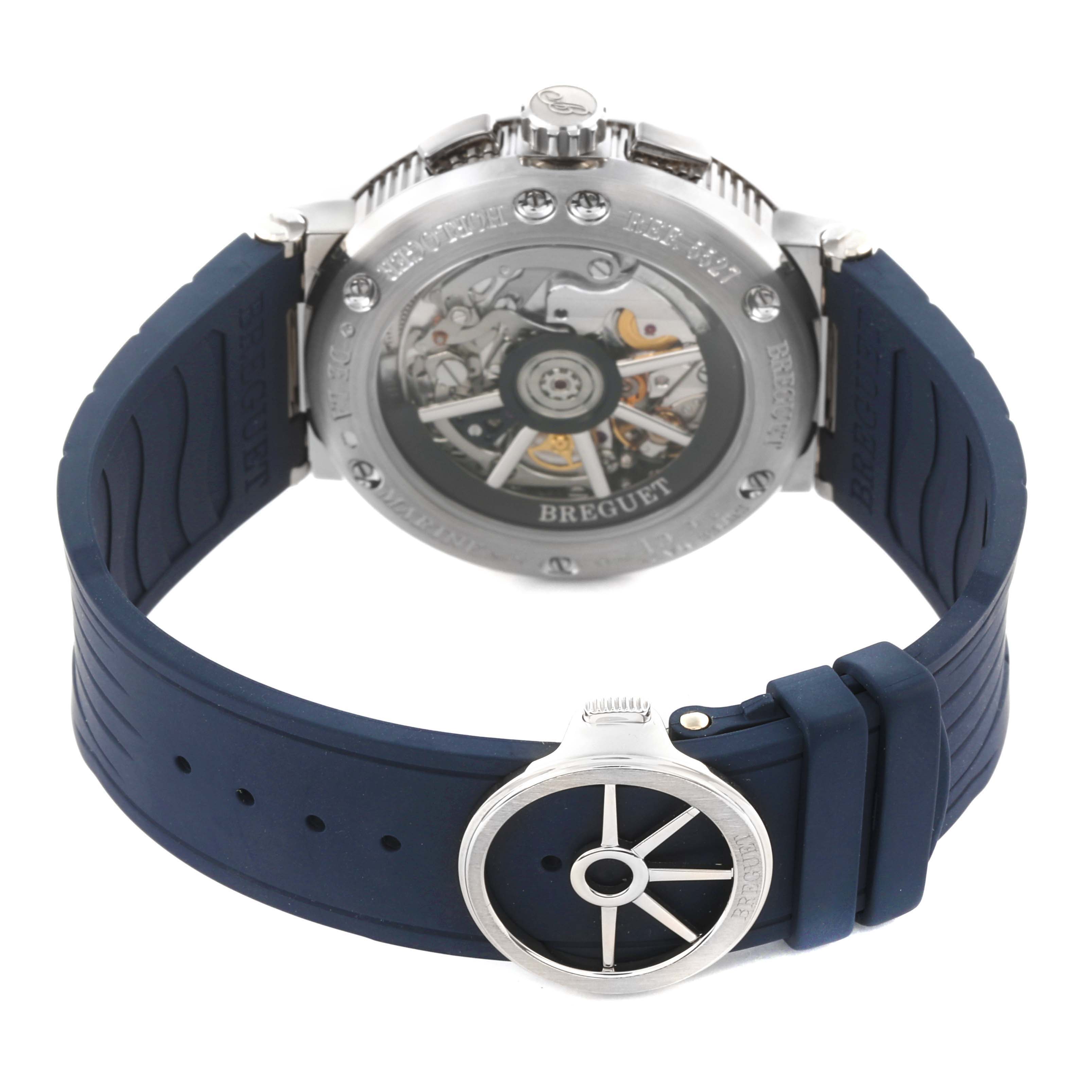 The image shows the back of a Breguet Marine 5527BB/Y2/9WV Men's White Gold Blue Dial 5527BB/Y2/9WV Men's White Gold Blue Dial watch, highlighting its transparent case back and detailed movement, with a blue strap.