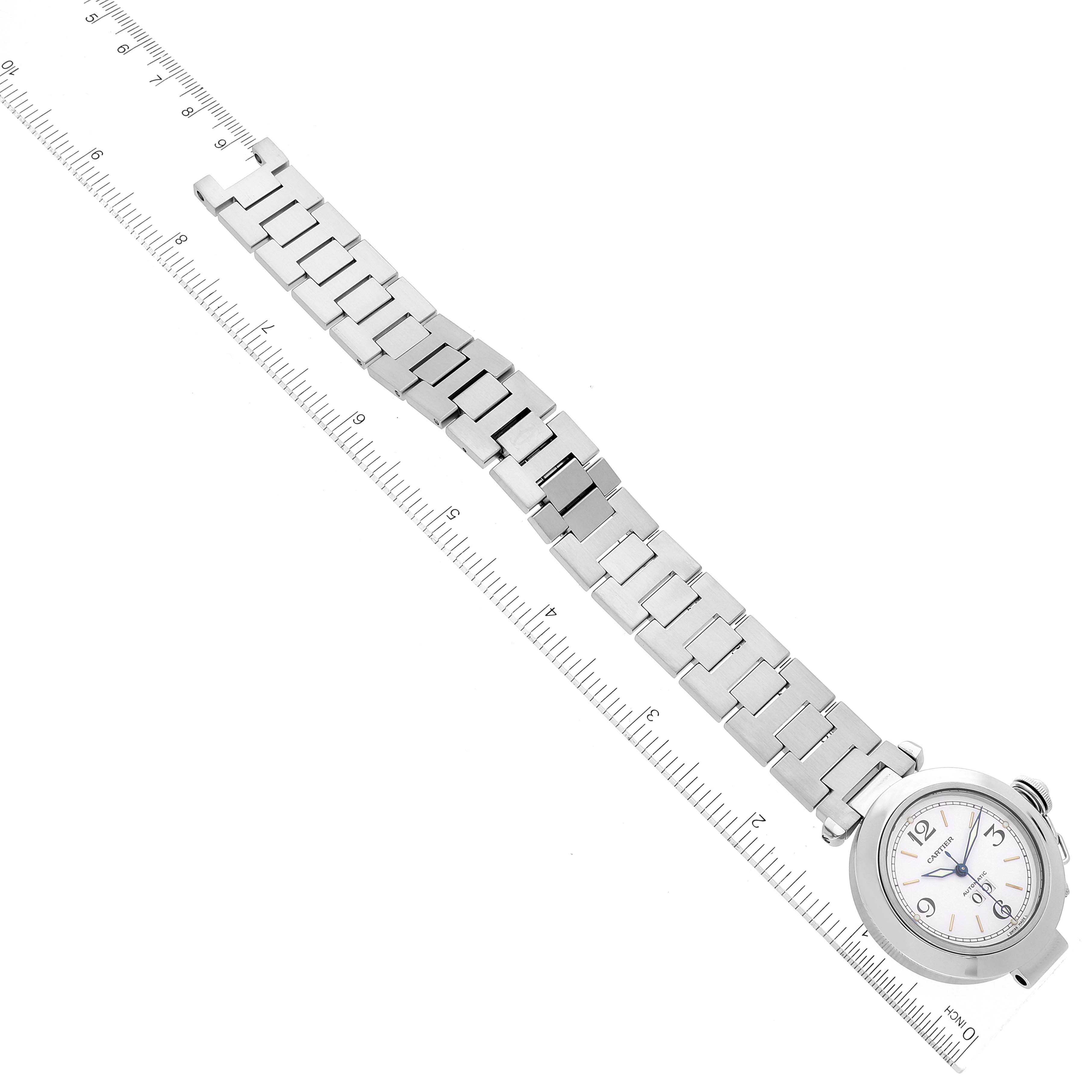 The image shows a Cartier Pasha W31055M7 Women's Stainless Steel White Dial W31055M7 Women's Stainless Steel White Dial watch lying flat with its stainless steel band extended, next to a ruler for scale.