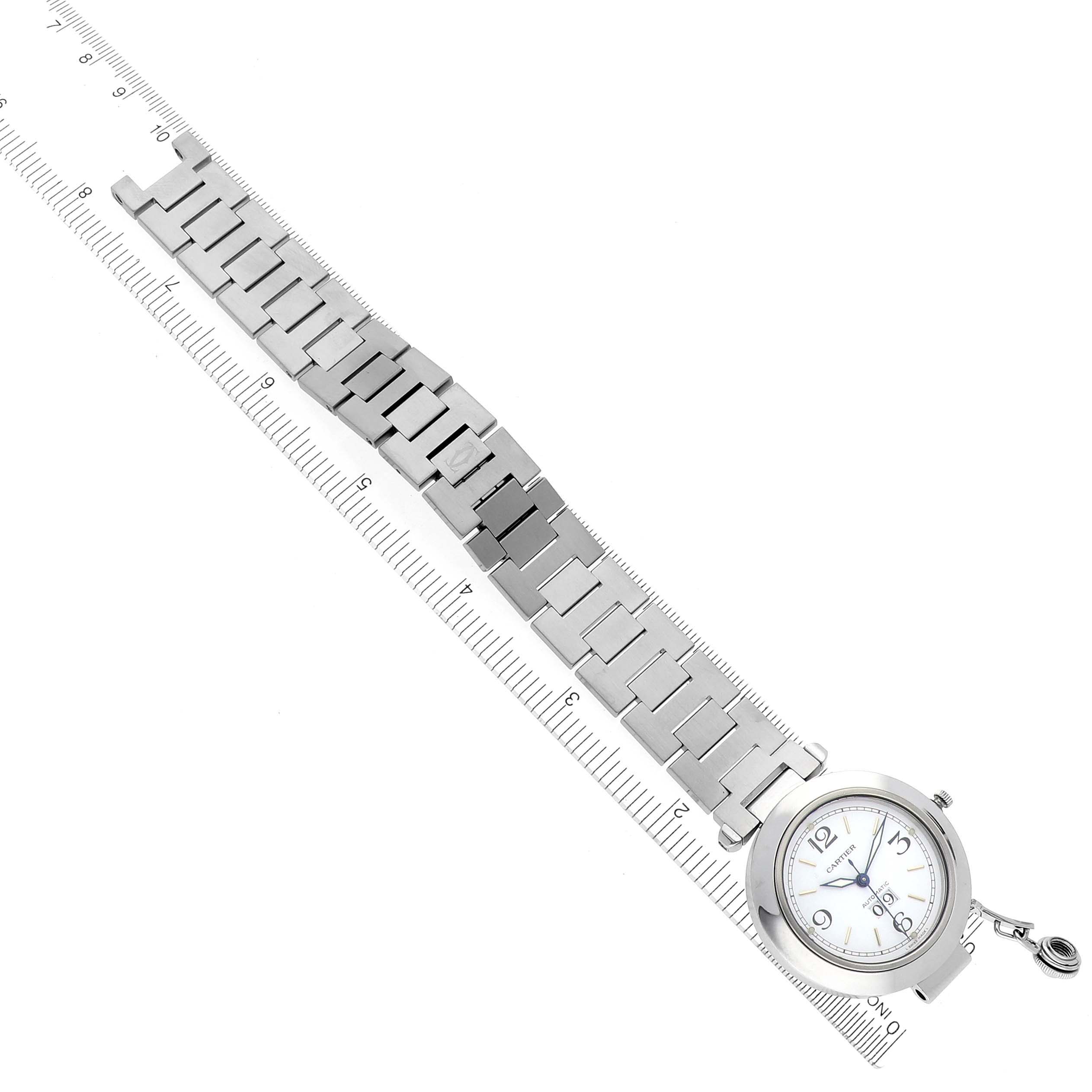 The image shows a top-down view of the Cartier Pasha W31044M7 Men's Stainless Steel White Dial W31044M7 Men's Stainless Steel White Dial watch, displaying the full bracelet and face with ruler for scale.
