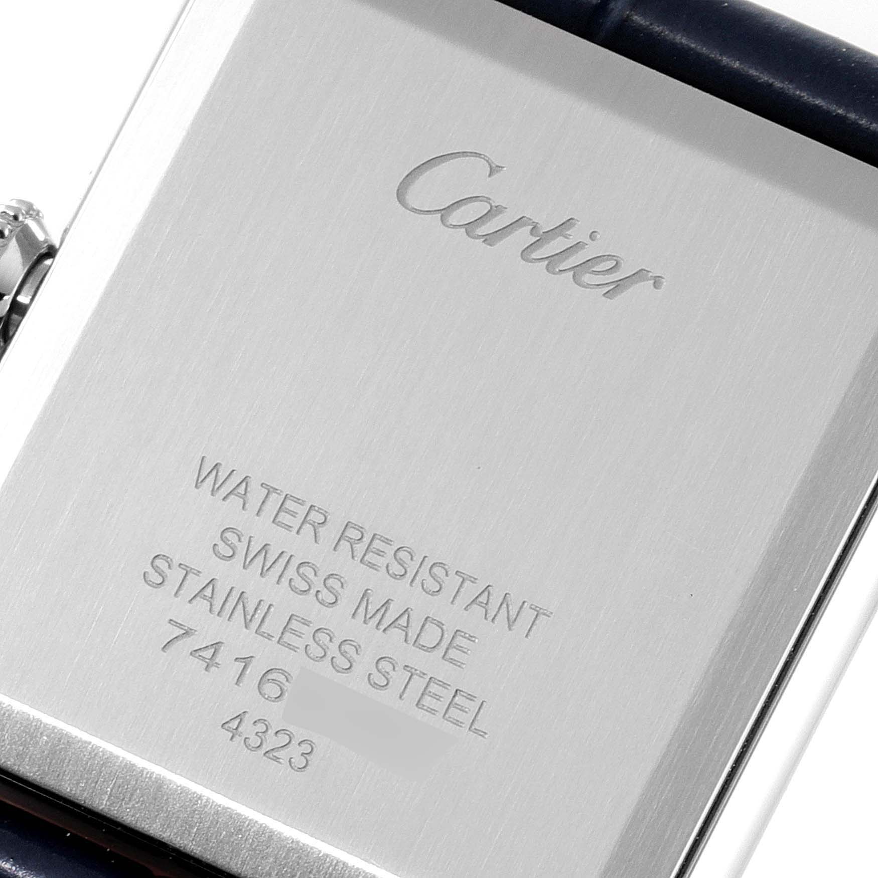The image shows the back of a Cartier Tank Must WSTA0055 Men's Stainless Steel Blue Dial WSTA0055 Men's Stainless Steel Blue Dial watch, highlighting its engravings and part of the strap.
