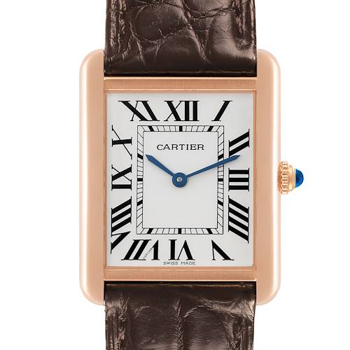 The Cartier Tank Solo watch is shown from a front angle, highlighting the face, Roman numerals, and crown with a blue gem.