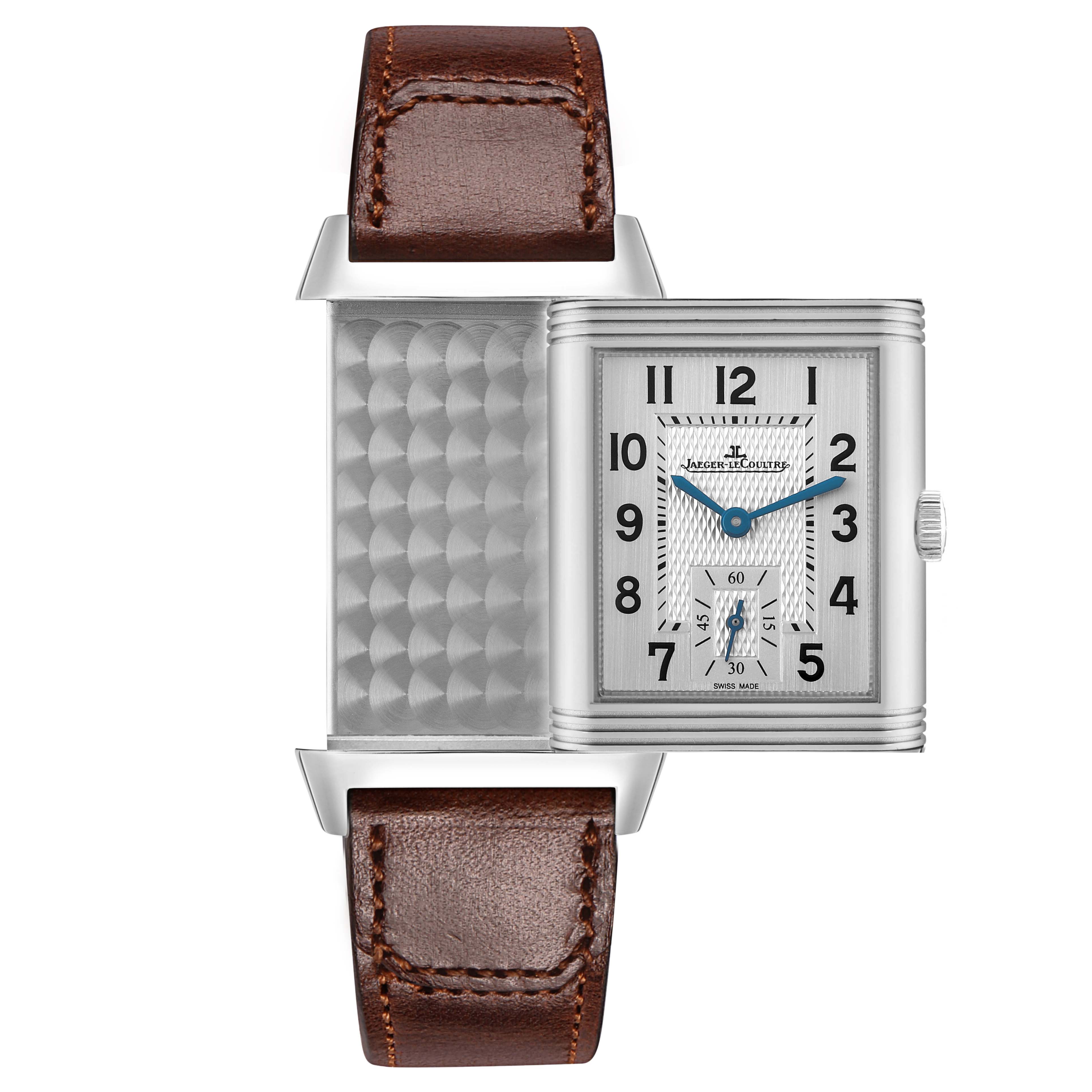 The image shows a Jaeger-LeCoultre Reverso watch with its case flipped to reveal the patterned back and dial with a brown leather strap.