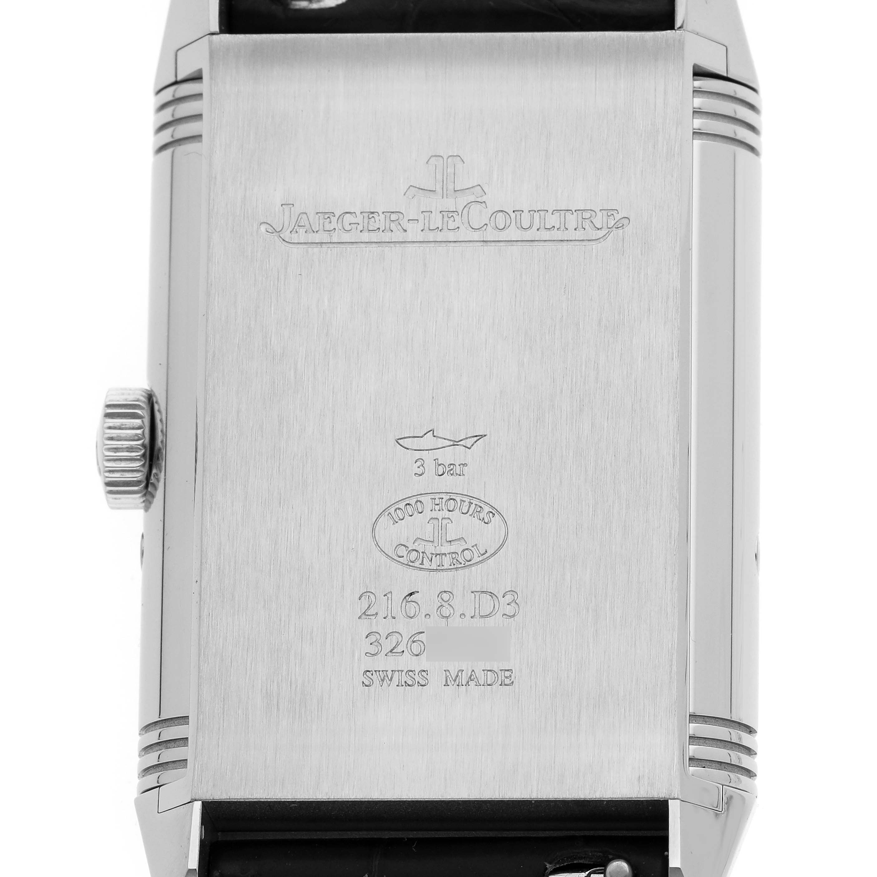 The Jaeger-LeCoultre Reverso watch is shown from the back, highlighting engravings and brand markings.