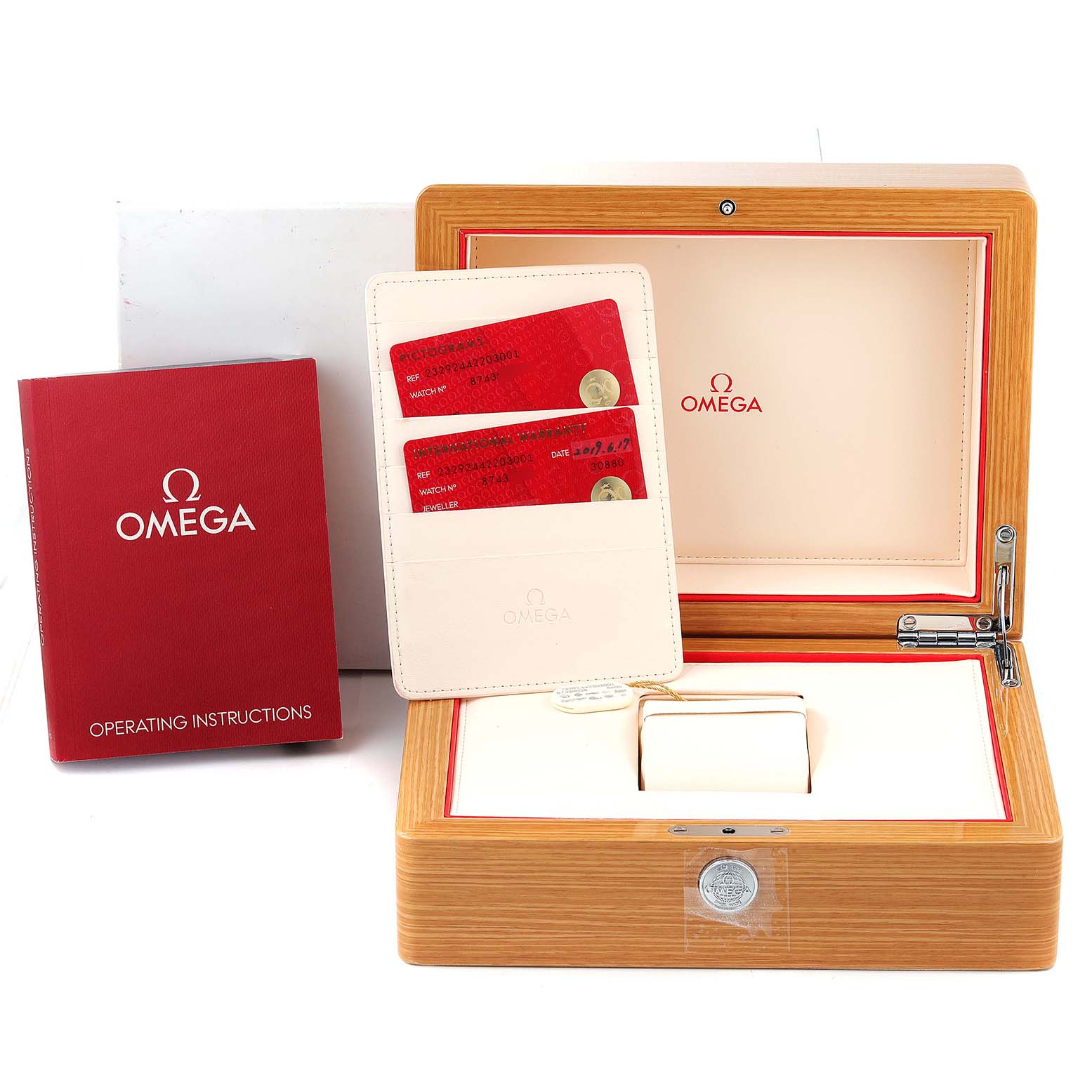 The image shows the packaging components of the Omega Planet Ocean 232.92.44.22.03.001 Men's Titanium Blue Dial 232.92.44.22.03.001 Men's Titanium Blue Dial watch, including a wooden box, operating instructions, and warranty cards.