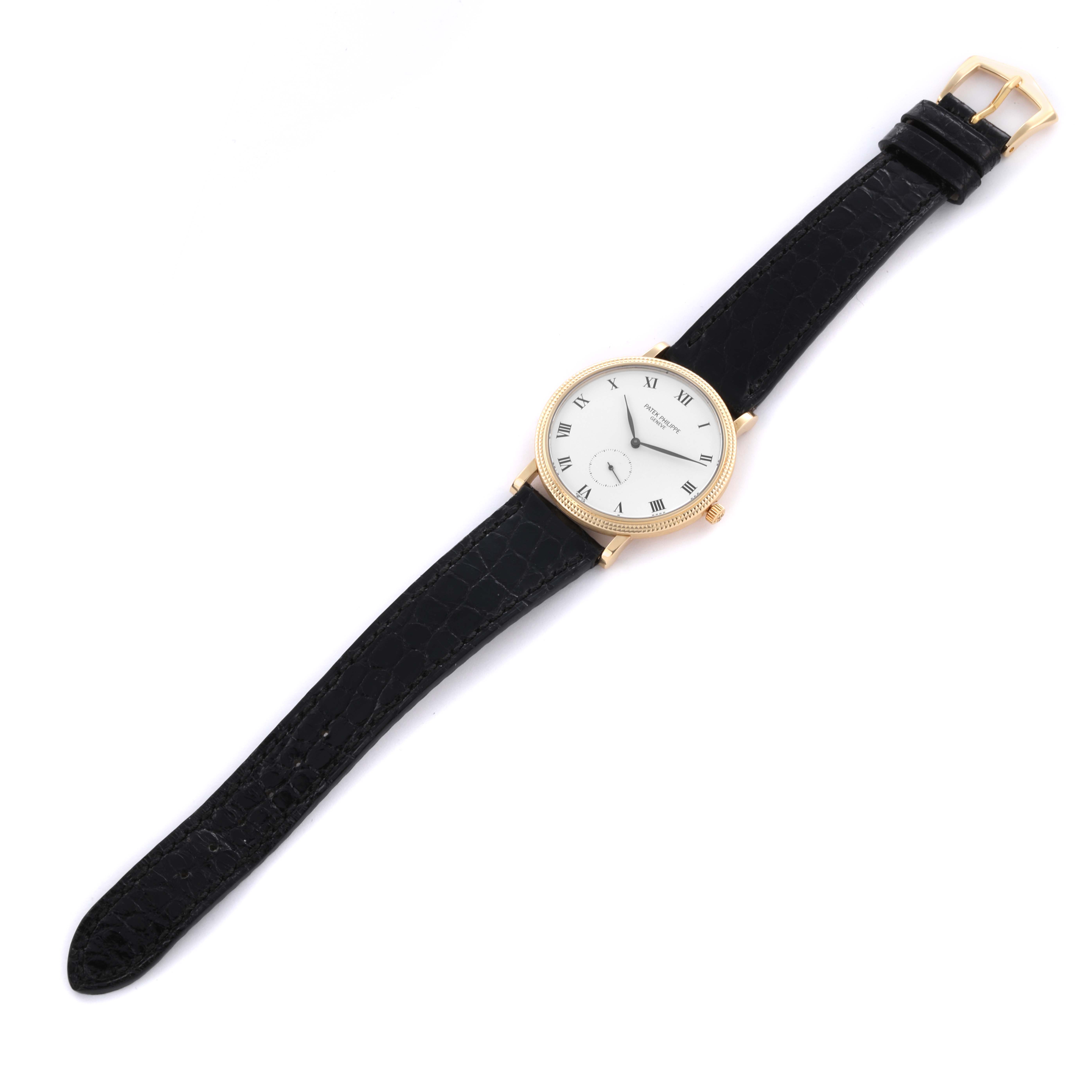 The Patek Philippe Calatrava 3919J Men's Yellow Gold White Dial 3919J Men's Yellow Gold White Dial watch is shown at a slight diagonal, displaying its face, case, and leather strap.