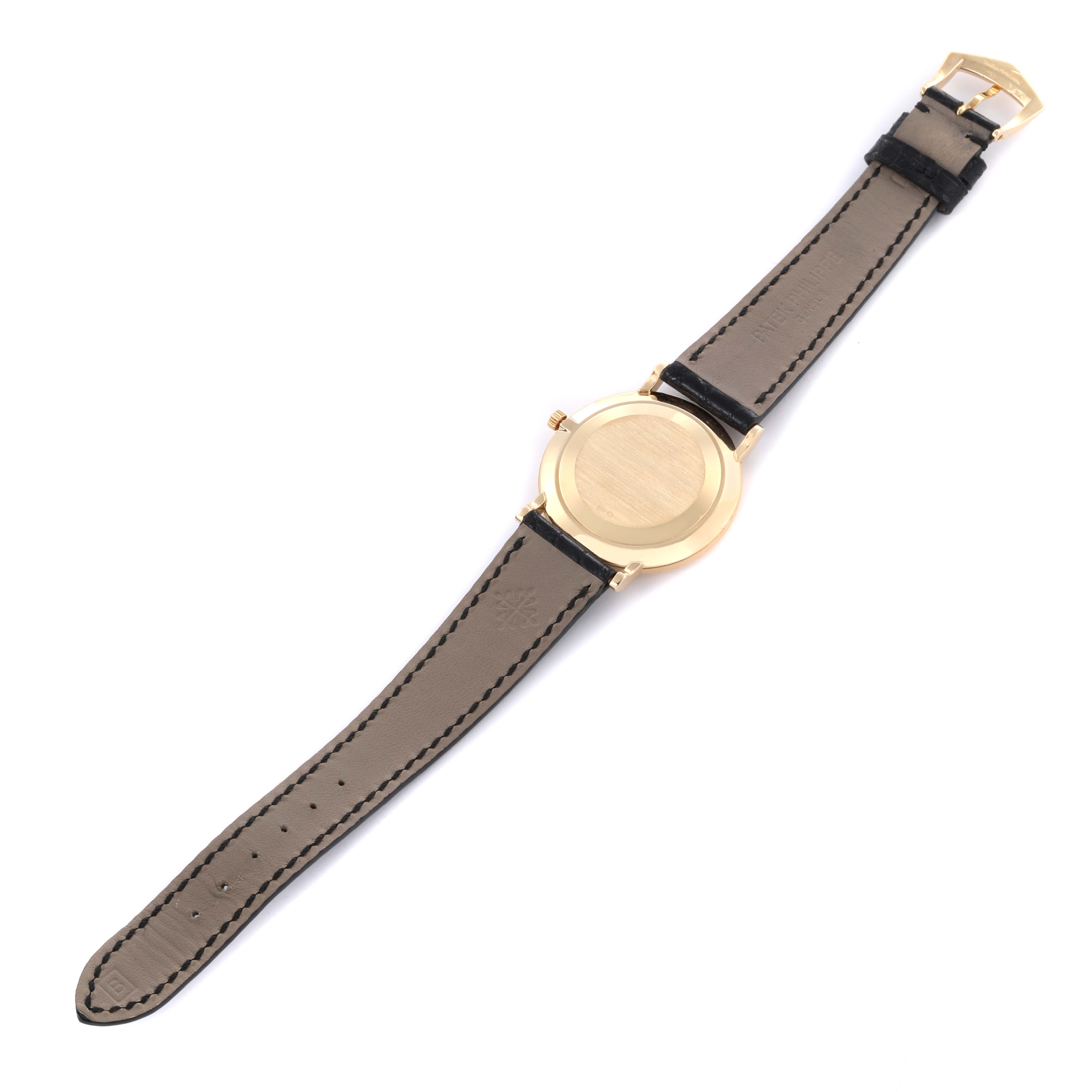 The image shows the back view of a Patek Philippe Calatrava 3919J Men's Yellow Gold White Dial 3919J Men's Yellow Gold White Dial watch, displaying the case back and leather straps.