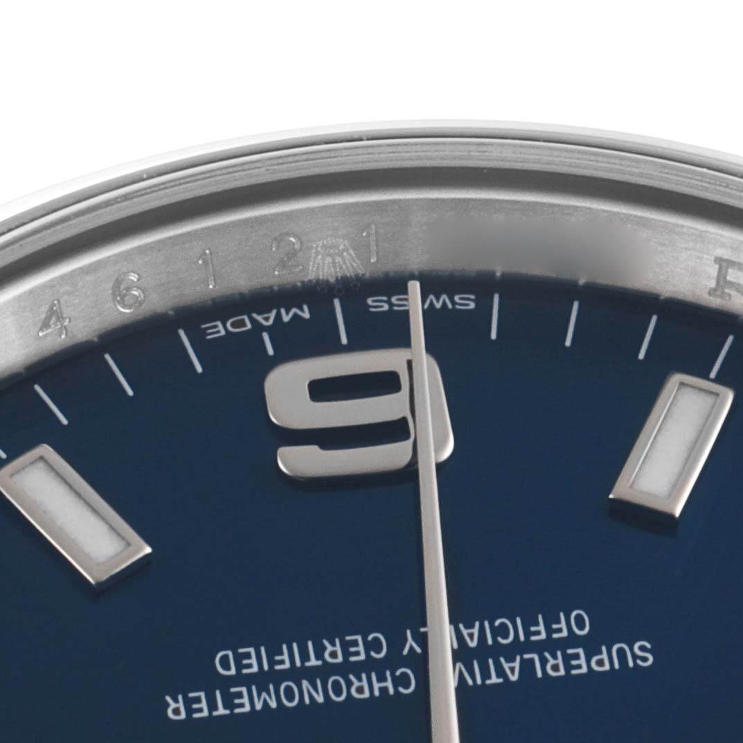 Close-up of the dial of a Rolex Air-King 114200 Men's Stainless Steel Blue Dial 114200 Men's Stainless Steel Blue Dial watch, focusing on the 9 o'clock marker, seconds hand, and part of the bezel.