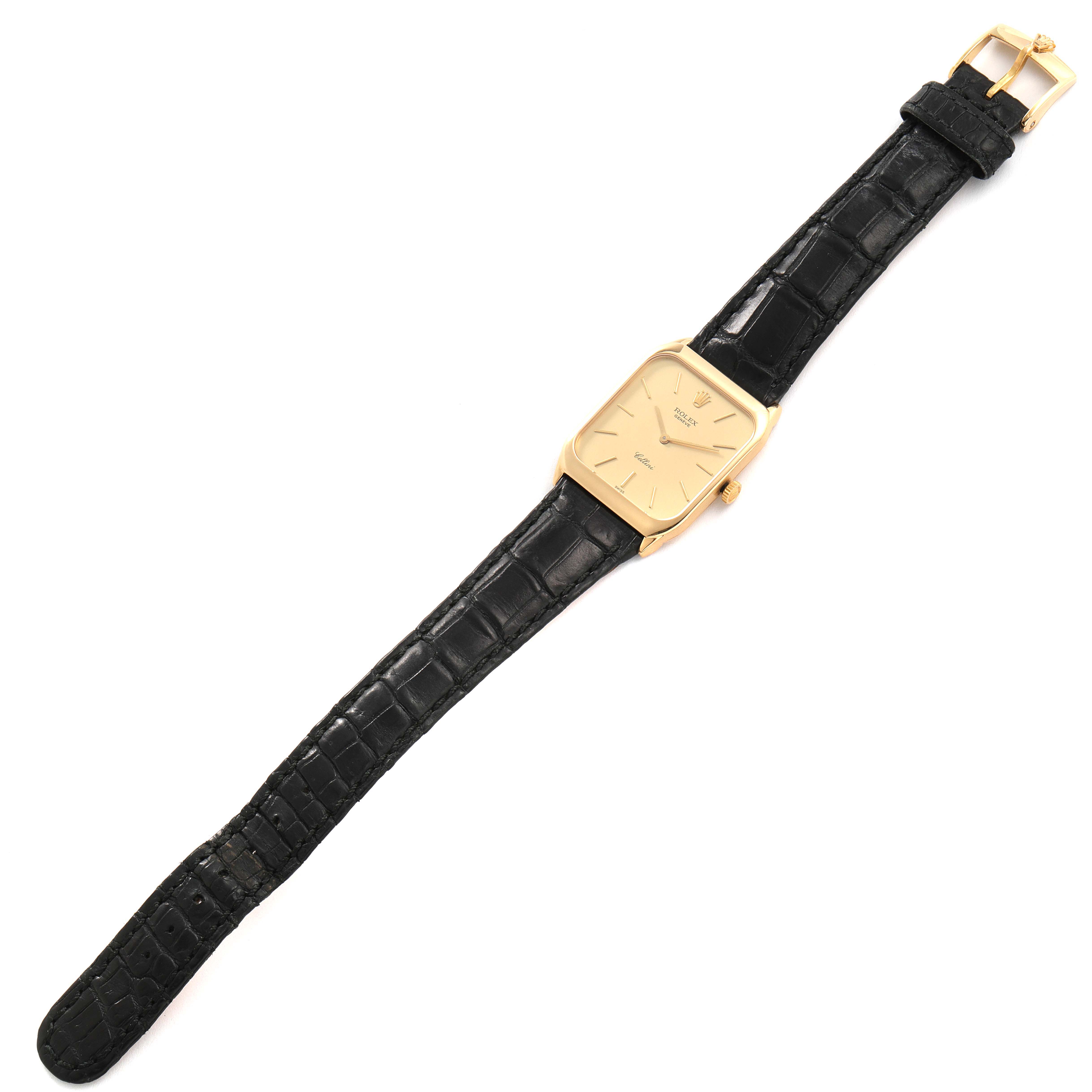 The image shows the front view of a Rolex Cellini 4135 Men's Yellow Gold Champagne Dial 4135 Men's Yellow Gold Champagne Dial watch with a rectangular gold case and a black leather strap.