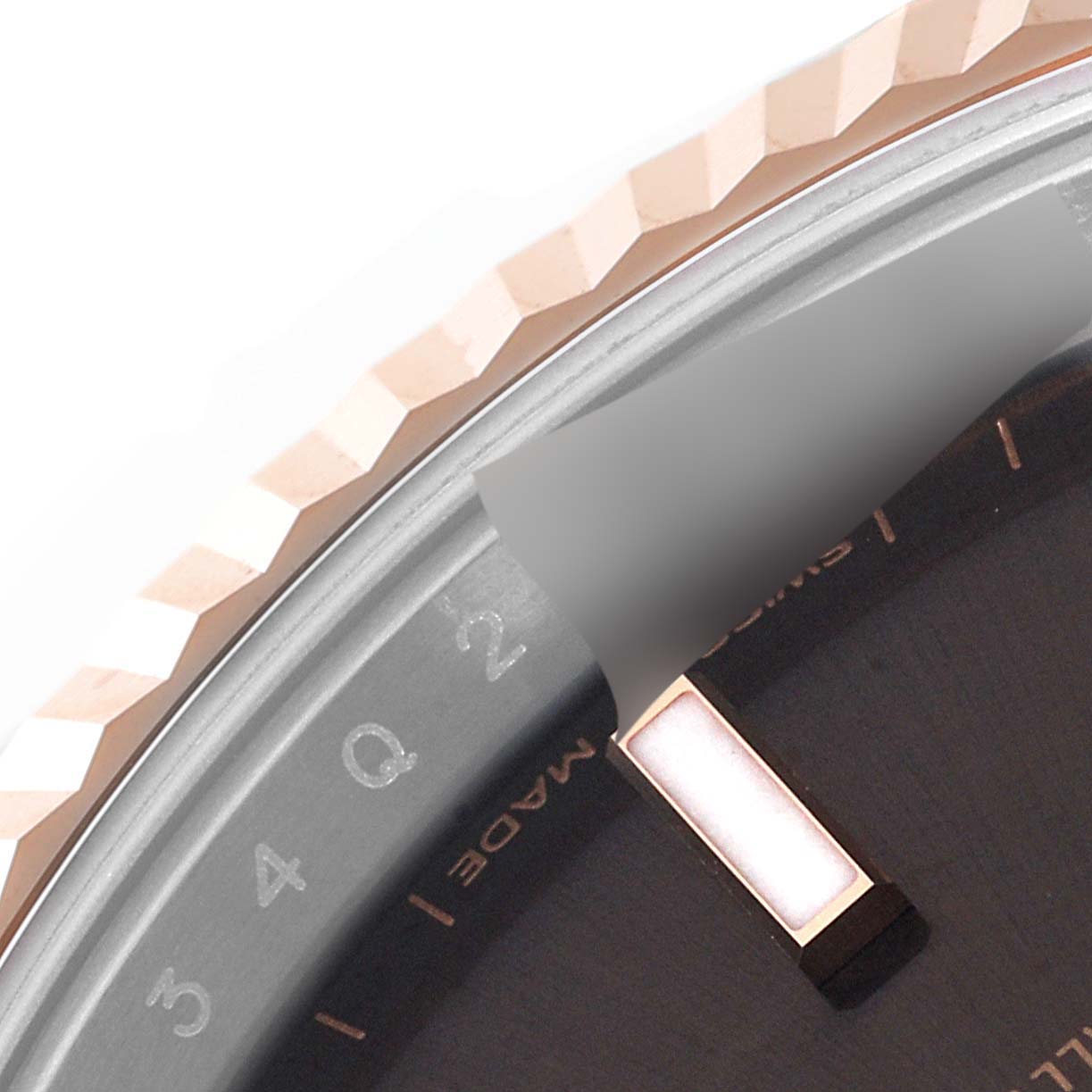 This close-up image of the Rolex Datejust 41 126331 Men's Steel and Gold (two tone) Brown Dial 126331 Men's Steel and Gold (two tone) Brown Dial model shows the bezel and part of the watch face, including an hour marker.