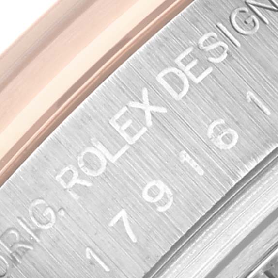 The image shows a close-up of the Rolex Datejust 179161 Women's Steel and Gold (two tone) Black Dial 179161 Women's Steel and Gold (two tone) Black Dial's stainless steel case with engraved design details.