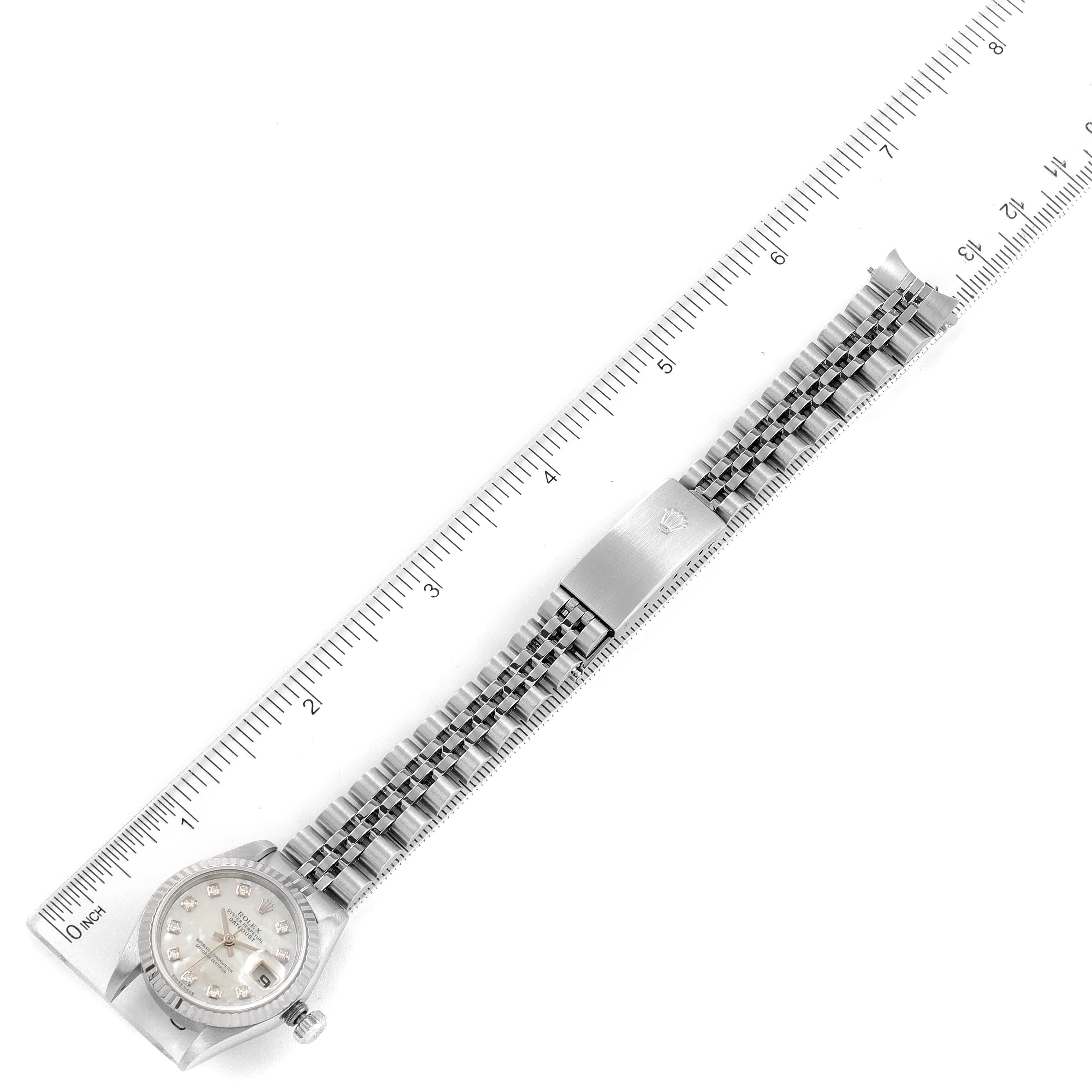 The image shows a top-down view of a Rolex Datejust 79174 Women's Stainless Steel Mother of Pearl Dial 79174 Women's Stainless Steel Mother of Pearl Dial watch with a stainless steel bracelet and clasp, alongside a ruler for measurement.