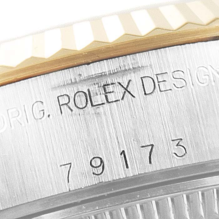 This close-up image shows the serial number and "ROLEX DESIGN" engraving on the side of a Rolex Datejust 79173 Women's Steel and Gold (two tone) Black Dial 79173 Women's Steel and Gold (two tone) Black Dial model's case.