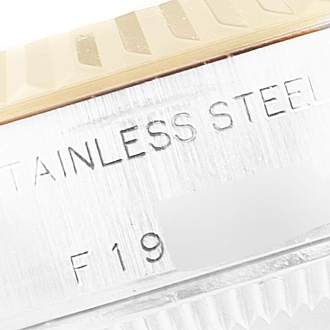 This close-up image shows the side of the bezel and part of the casing of a Rolex Datejust 79173 Women's Steel and Gold (two tone) Black Dial 79173 Women's Steel and Gold (two tone) Black Dial watch, displaying "stainless steel" engraving.