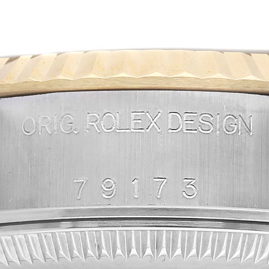 The image shows a close-up of the side of a Rolex Datejust 79173 Women's Steel and Gold (two tone) Champagne Dial watch, focusing on the bezel and engraved markings.