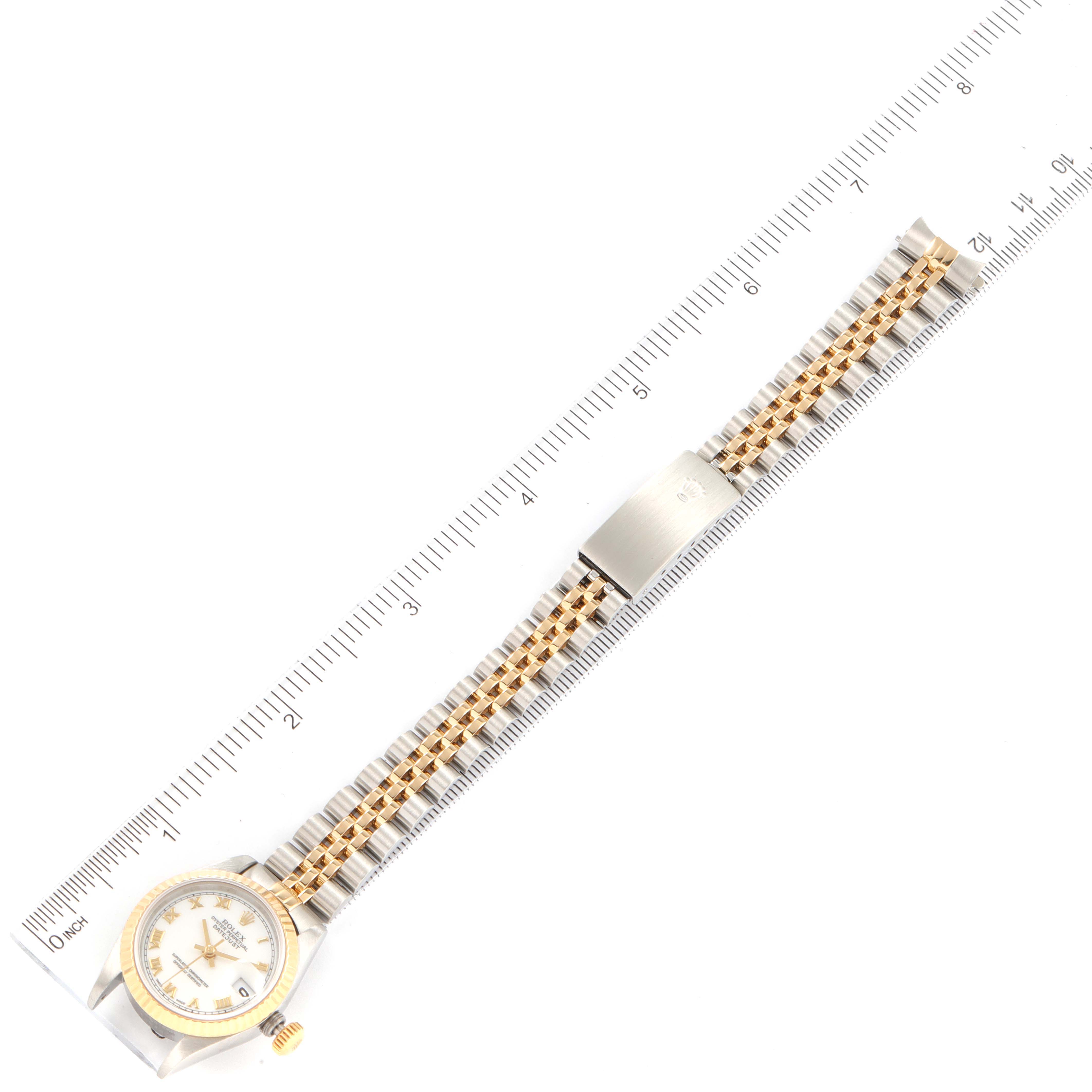 The Rolex Datejust 69173 Women
s Steel and Gold (two tone) White Dial 69173 Women
s Steel and Gold (two tone) White Dial watch is shown from a top-down angle, displaying the face, bezel, and bracelet along with a ruler for scale.