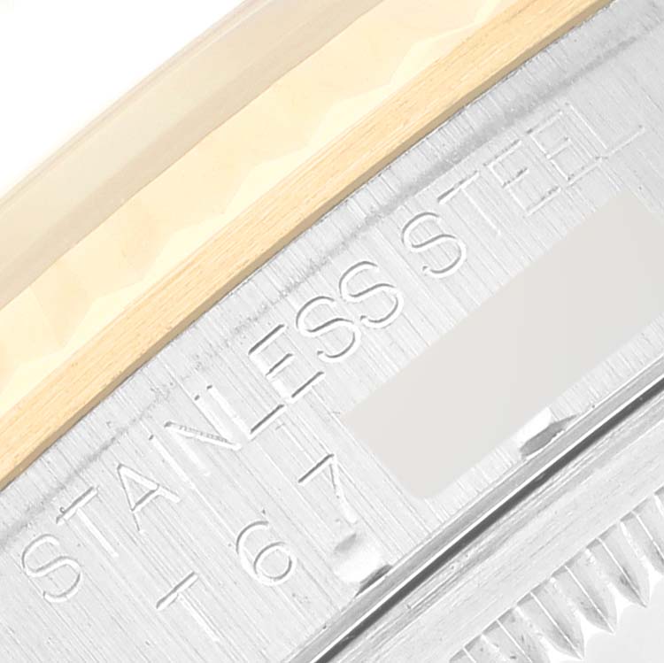 This close-up shot of the Rolex Datejust 16233 Men's Steel and Gold (two tone) Mother of Pearl Dial 16233 Men's Steel and Gold (two tone) Mother of Pearl Dial watch shows the edge of the bezel and engraved "STAINLESS STEEL" marking.