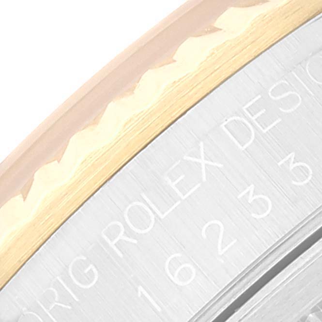 The image shows a close-up angled view of the bezel and case side of a Rolex Datejust 16233 Men's Steel and Gold (two tone) White Dial 16233 Men's Steel and Gold (two tone) White Dial watch, highlighting part of its engraving.
