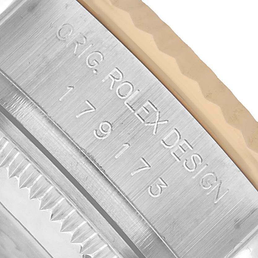 The image shows a close-up of the side of a Rolex Datejust 179173 Women's Steel and Gold (two tone) White Dial watch case with engraved model details.