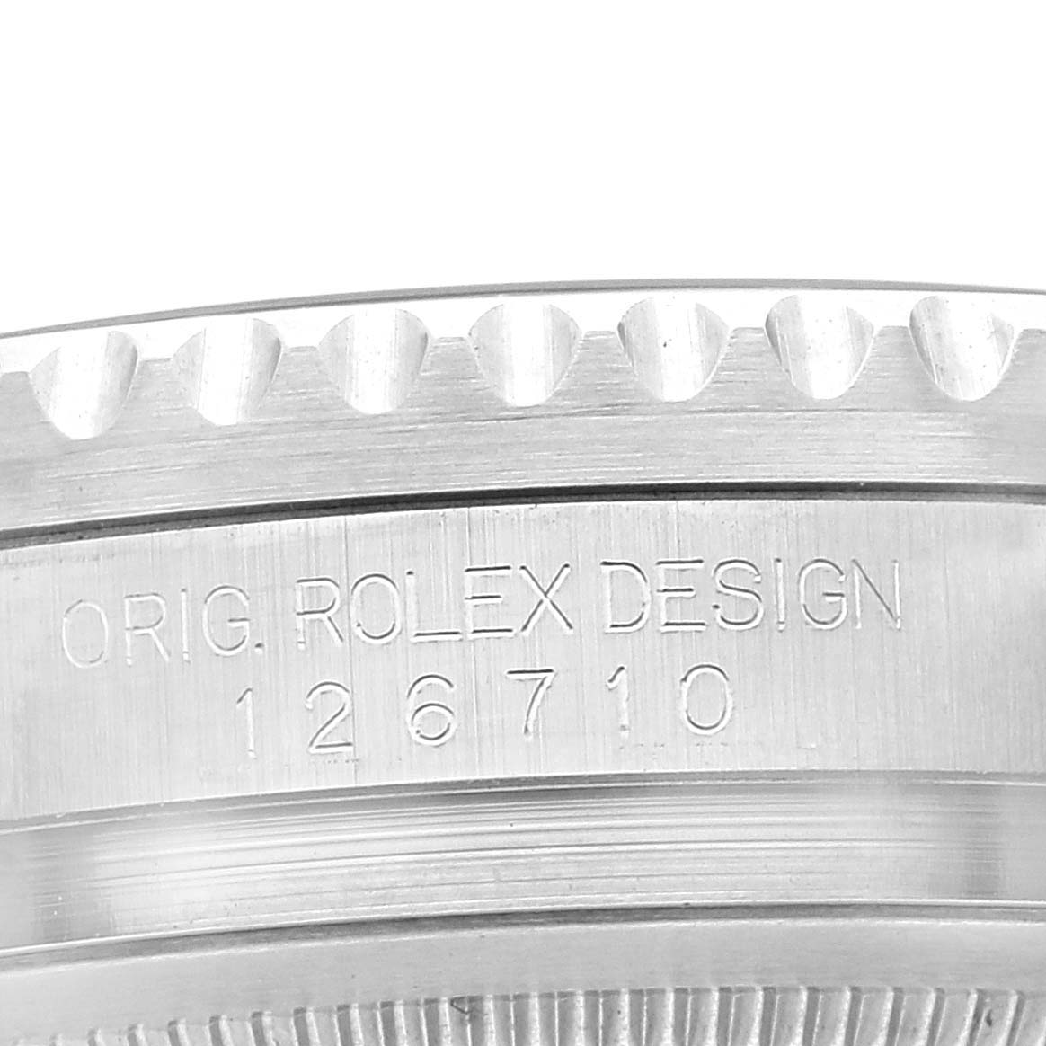 The image shows a close-up of the side of the bezel and case of a Rolex GMT-Master 126710 Men's Stainless Steel Black Dial 126710 Men's Stainless Steel Black Dial, engraved with "ORIG. ROLEX DESIGN 126710".