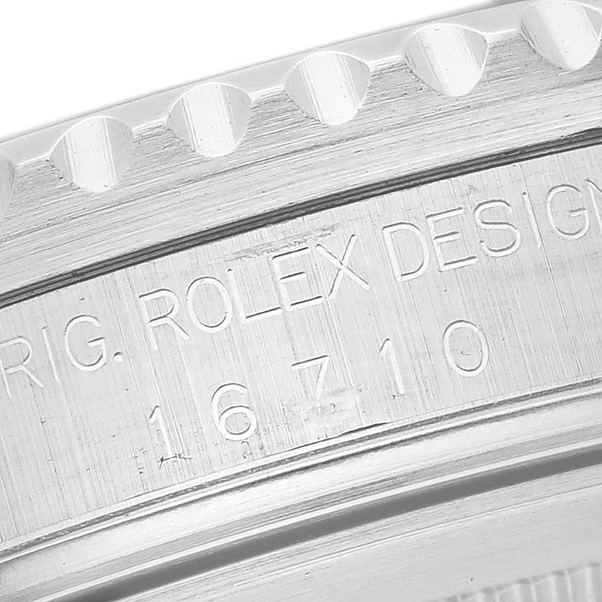 The image shows a close-up of the engraved side of the bezel of a Rolex GMT-Master 16710 Men's Stainless Steel Black Dial 16710 Men's Stainless Steel Black Dial watch.