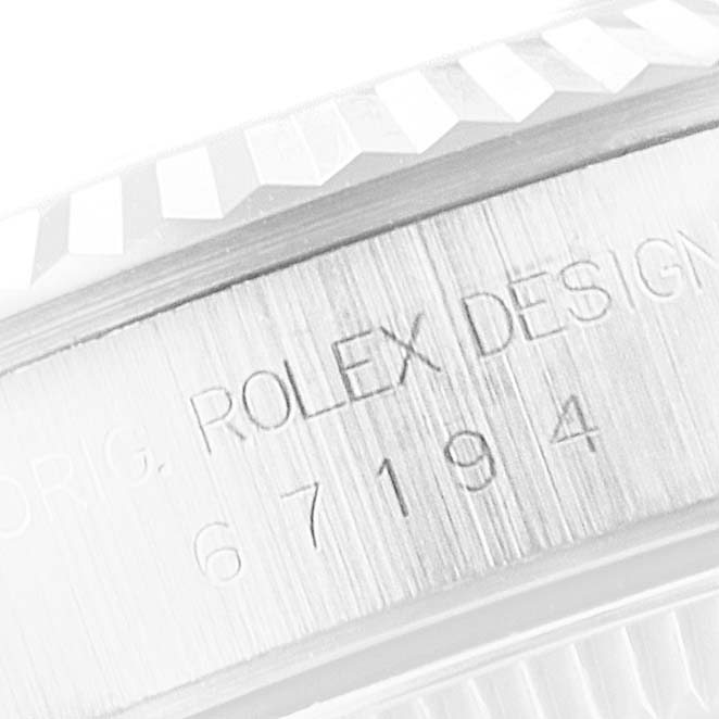 The image is a close-up of the side engraving on a Rolex Oyster Perpetual 67194 Women's Stainless Steel Silver Dial 67194 Women's Stainless Steel Silver Dial watch bezel.