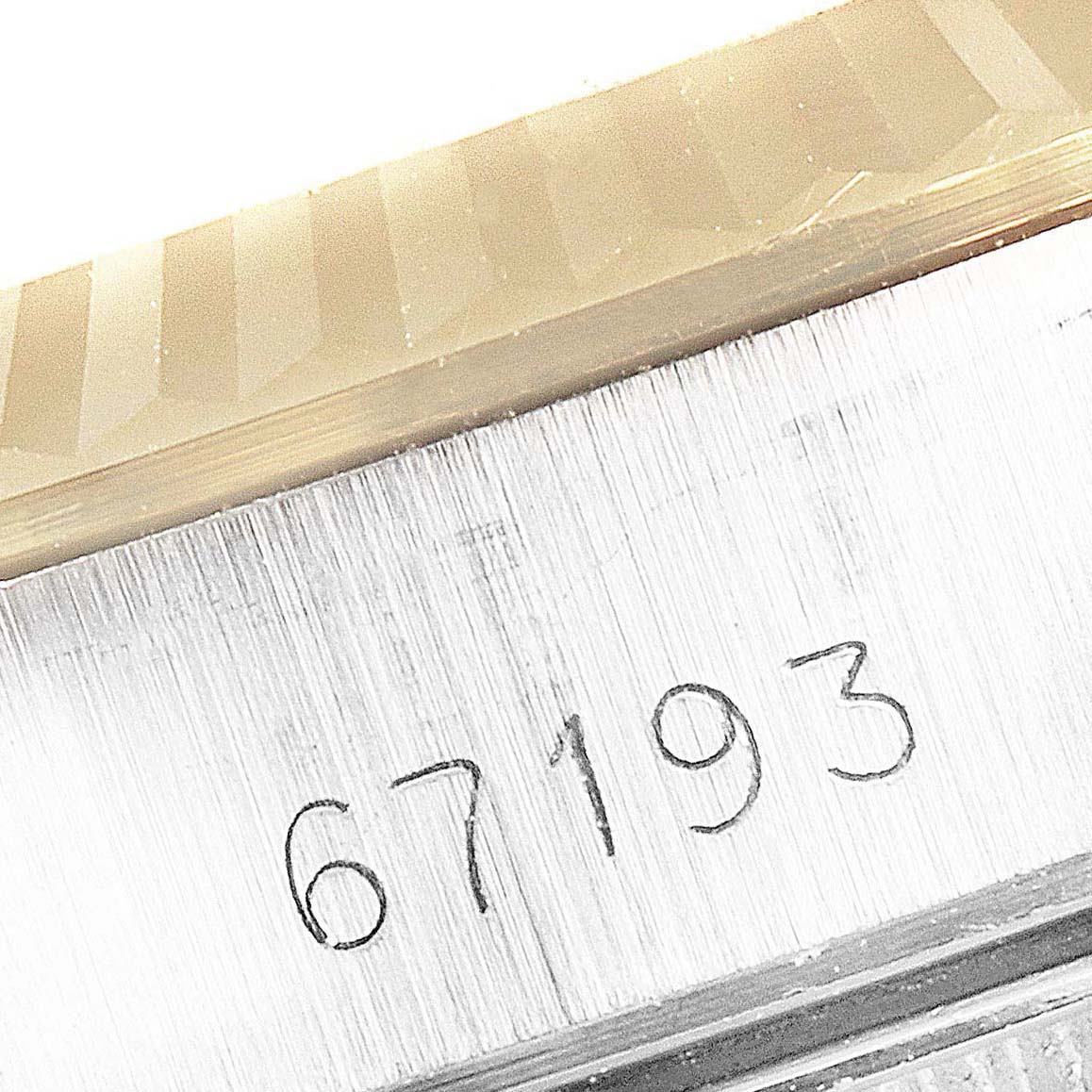 The image shows a close-up of the model number "67193" engraved on a Rolex Oyster Perpetual 67193 Women
s Steel and Gold (two tone) Champagne Dial 67193 Women
s Steel and Gold (two tone) Champagne Dial watch bezel and case.