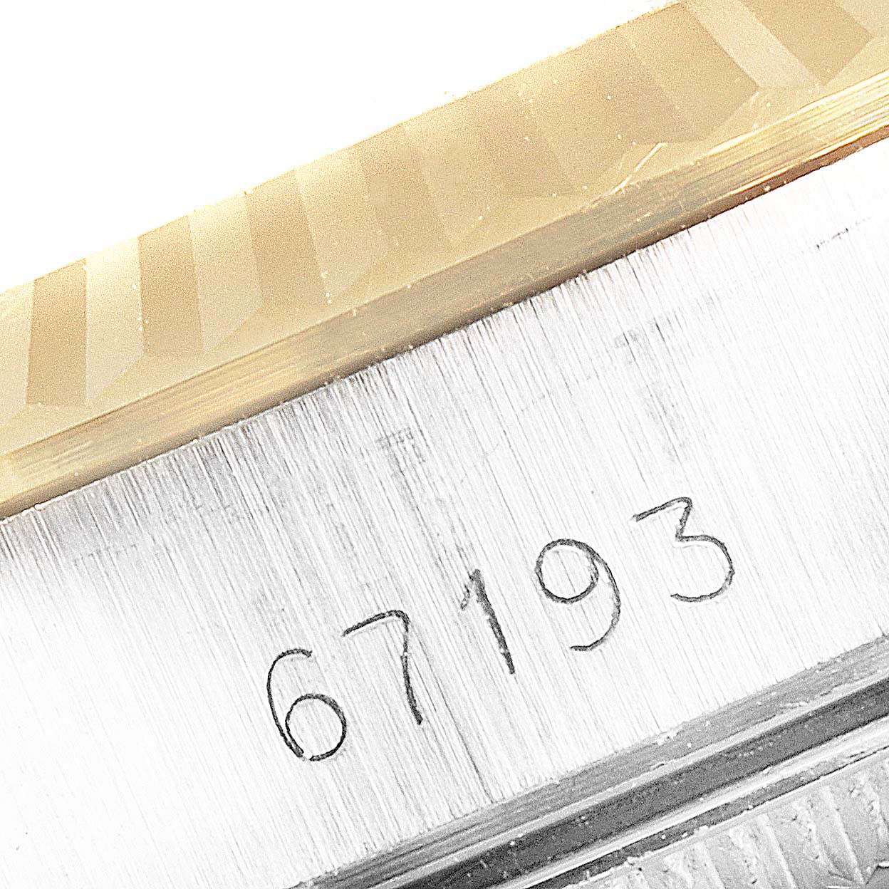 This image shows a close-up angle of the model number "67193" engraved on the case of a Rolex Oyster Perpetual 67193 Women's Steel and Gold (two tone) Champagne Dial 67193 Women's Steel and Gold (two tone) Champagne Dial watch.