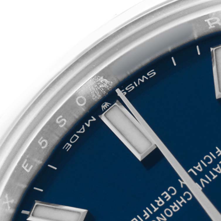 The image shows a close-up of the edge of the blue dial and bezel of a Rolex Oyster Perpetual 277200 Women's Stainless Steel Blue Dial, highlighting markers and "Swiss Made."