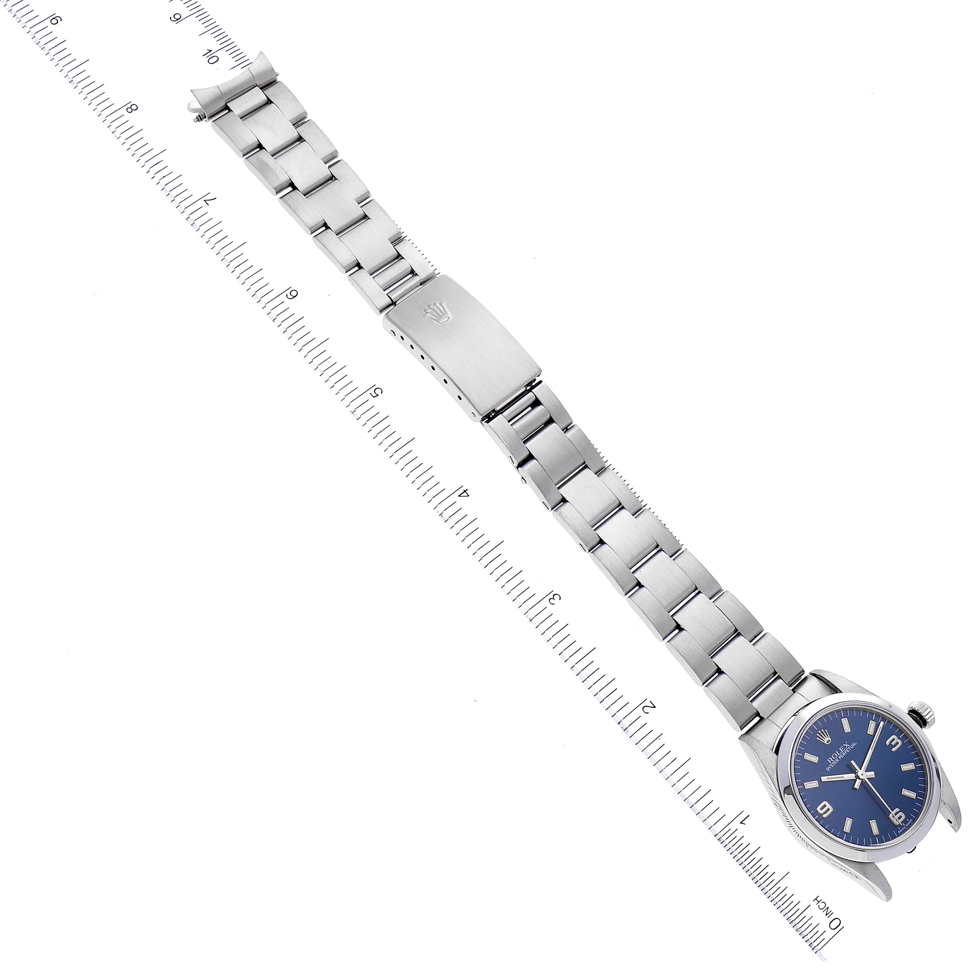 This image showcases a Rolex Mid-Size 77080 Women
s Stainless Steel Blue Dial 77080 Women
s Stainless Steel Blue Dial model watch laid flat, displaying the watch face and full bracelet against a ruler for scale.