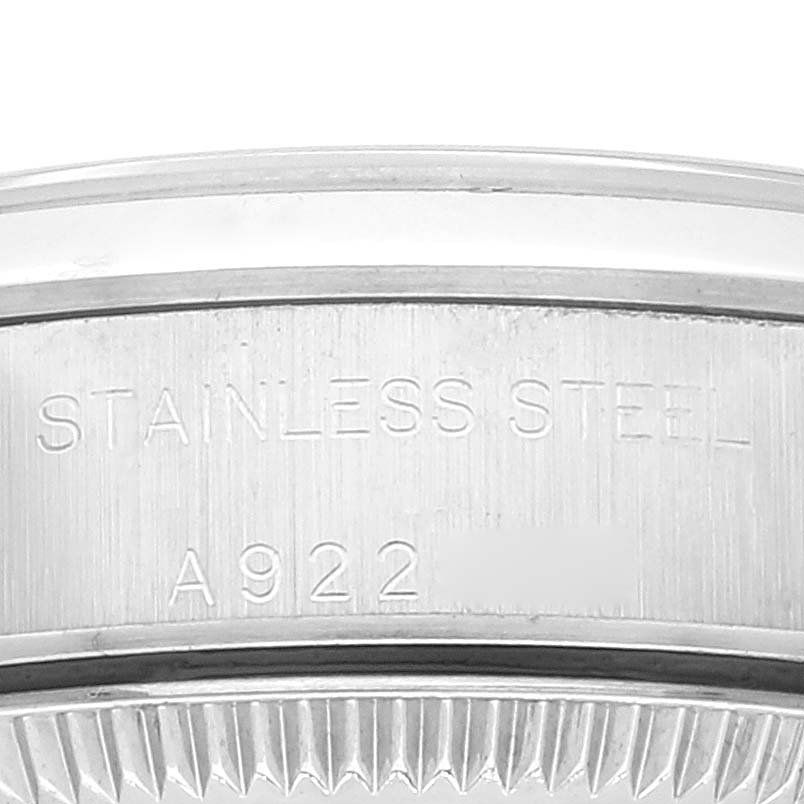 The image shows a close-up of the stainless steel case back edge of the Rolex Oyster Perpetual 76080 Women
s Stainless Steel Pink Dial 76080 Women
s Stainless Steel Pink Dial watch with engraved details.