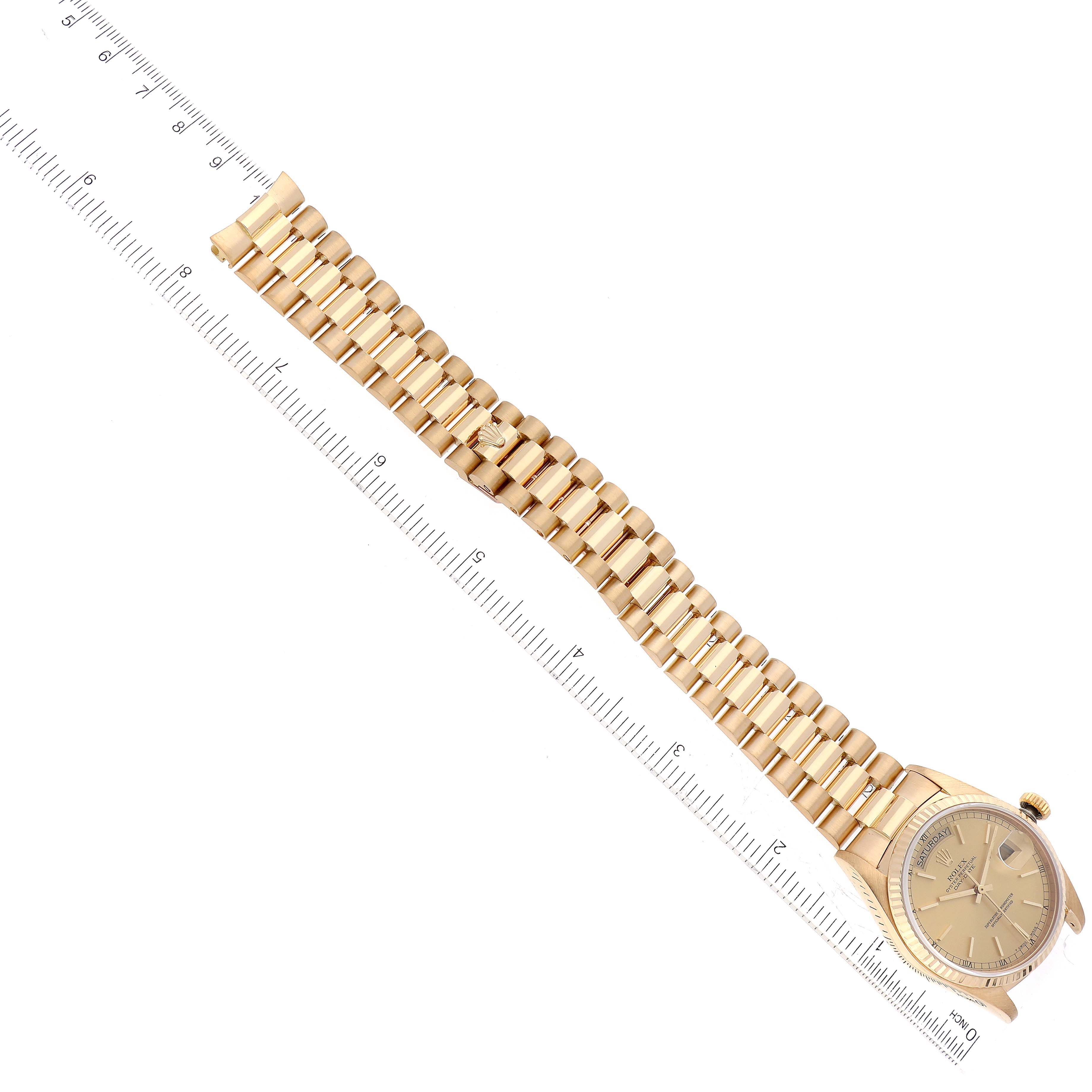 The image shows a Rolex President 18038 Men
s Yellow Gold Champagne Dial 18038 Men
s Yellow Gold Champagne Dial model watch laid flat with its entire bracelet visible alongside a ruler for scale.