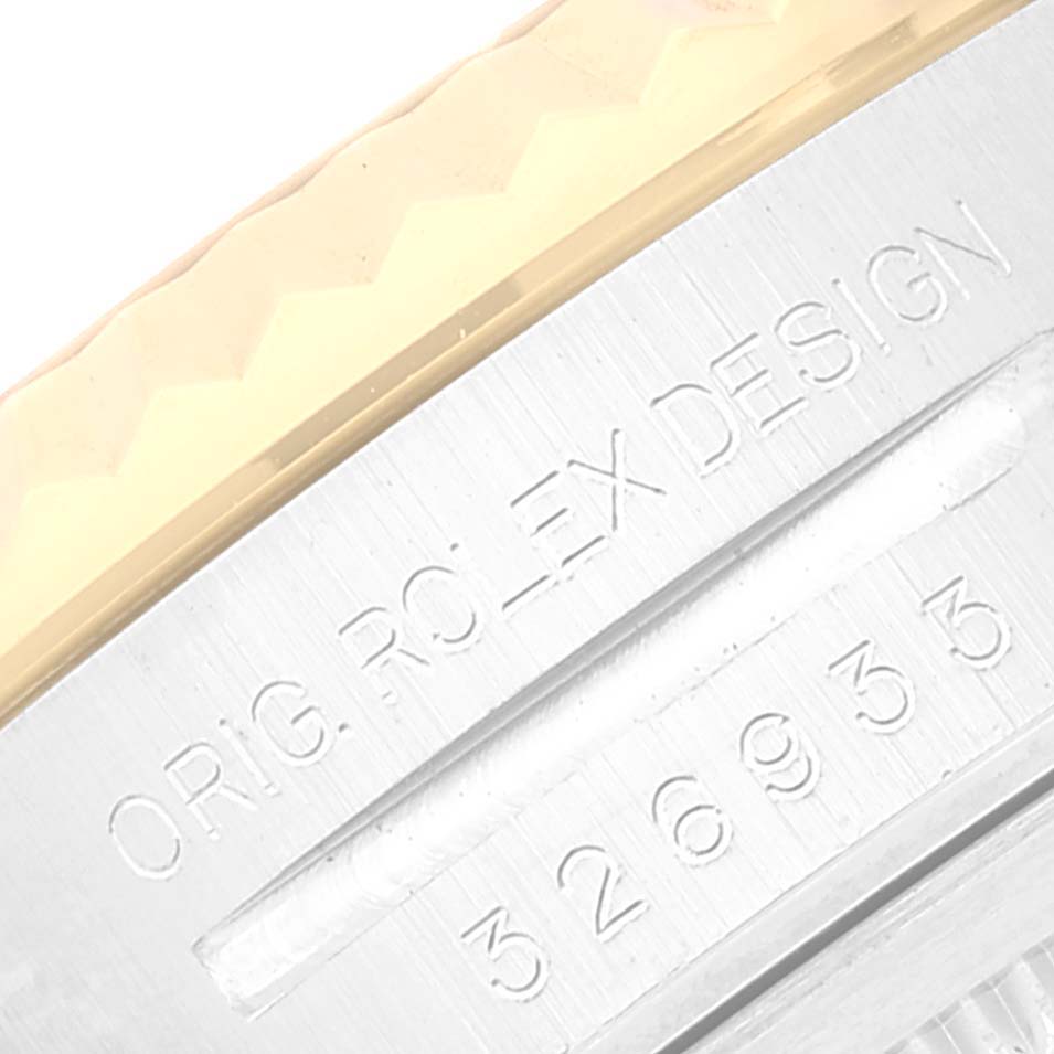 The image shows a close-up of the side of a Rolex Sky-Dweller 326933 Men's Steel and Gold (two tone) Champagne Dial 326933 Men's Steel and Gold (two tone) Champagne Dial watch case, displaying the serial number and "ORIG ROLEX DESIGN" inscription.