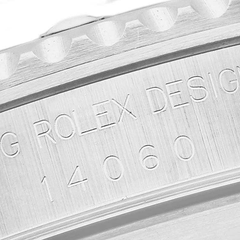 The image shows a close-up of the engraved case side of a Rolex Submariner 14060 Men
s Stainless Steel Black Dial 14060 Men
s Stainless Steel Black Dial, focusing on text and model number.