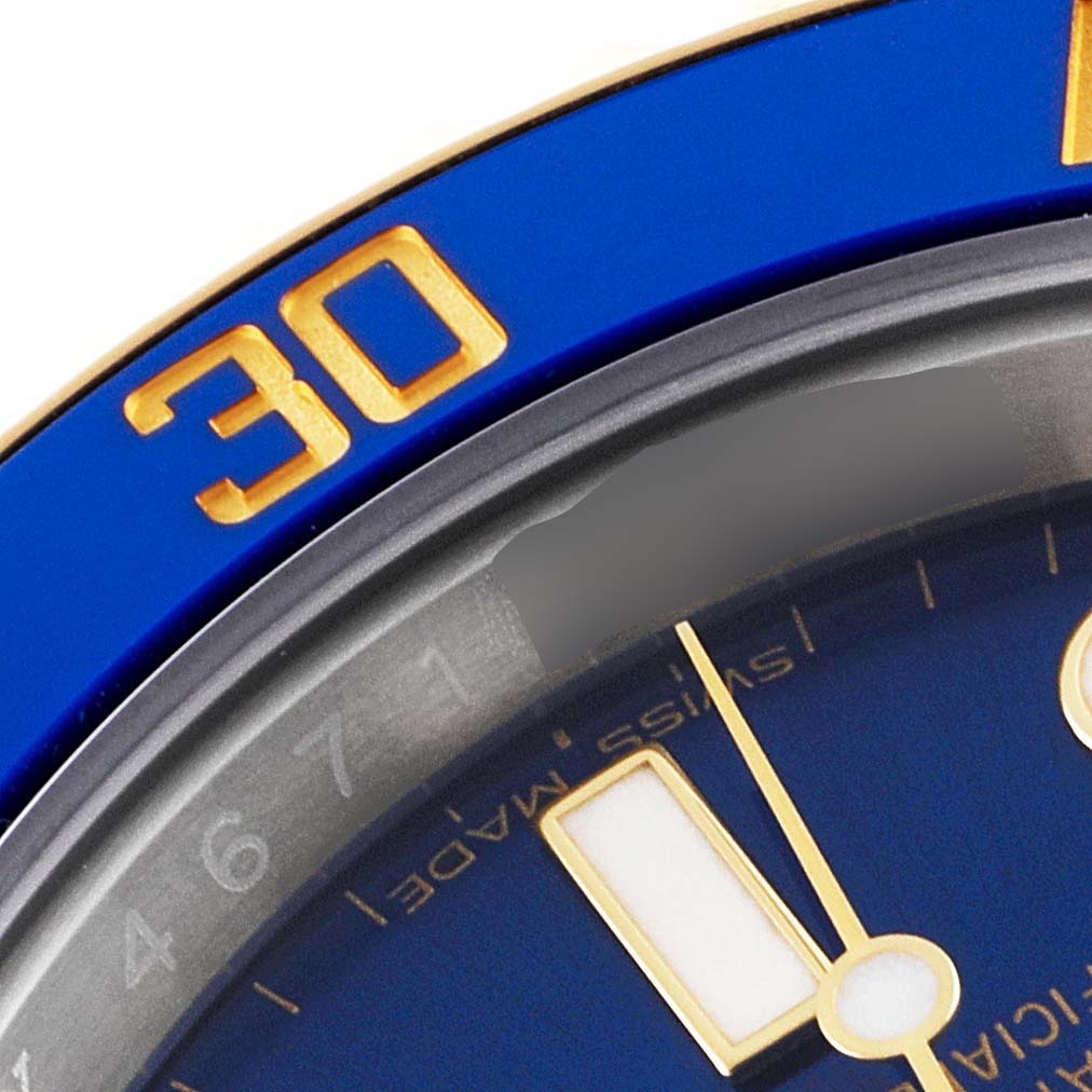 This close-up image shows the bezel and part of the dial of a blue Rolex Submariner 116613 Men's Steel and Gold (two tone) Blue Dial 116613 Men's Steel and Gold (two tone) Blue Dial watch.