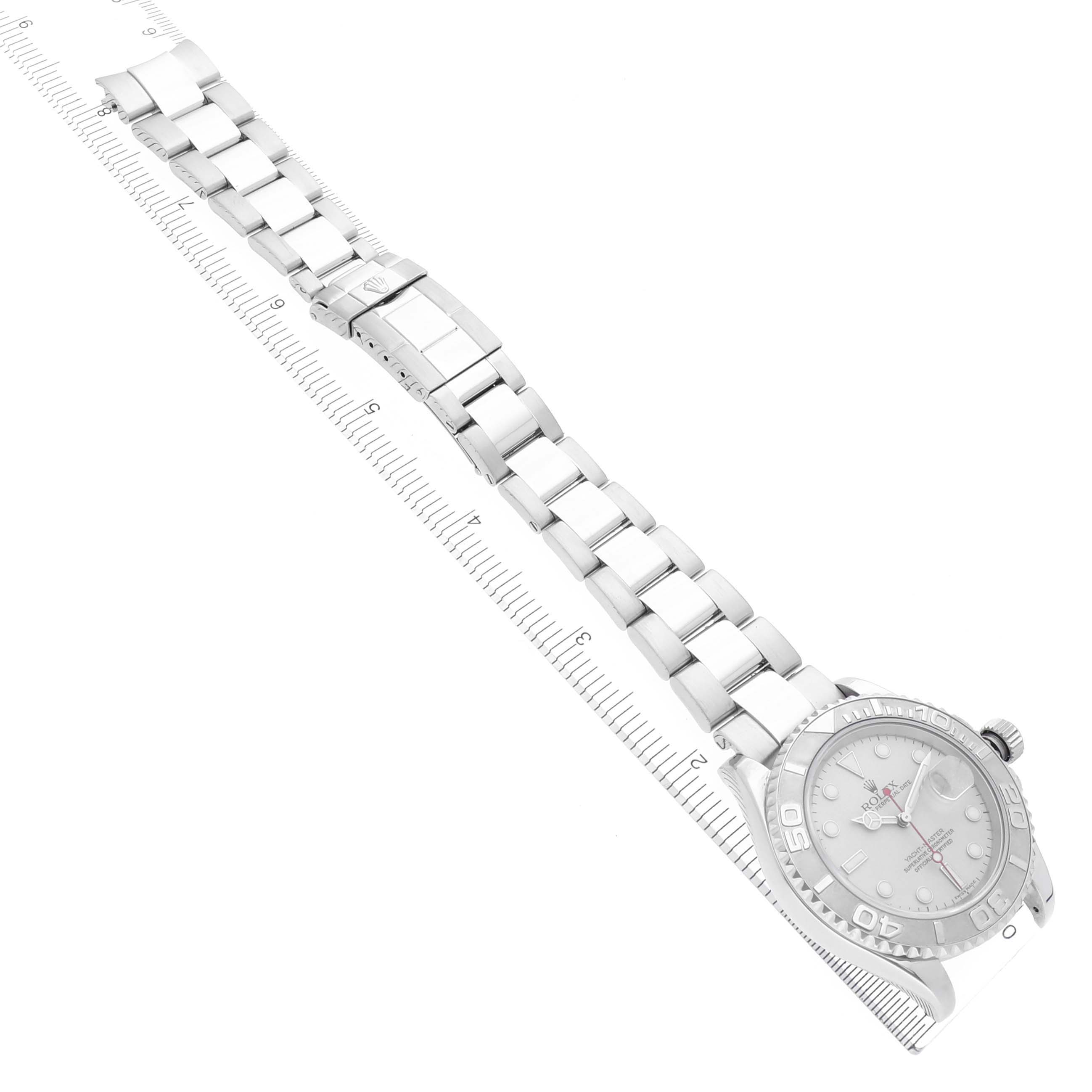 The Rolex Yacht-Master 16622 Men's Steel and Gold (two tone) Silver Dial 16622 Men's Steel and Gold (two tone) Silver Dial watch is shown from an angled top-down view, displaying the full bracelet and face beside a ruler.