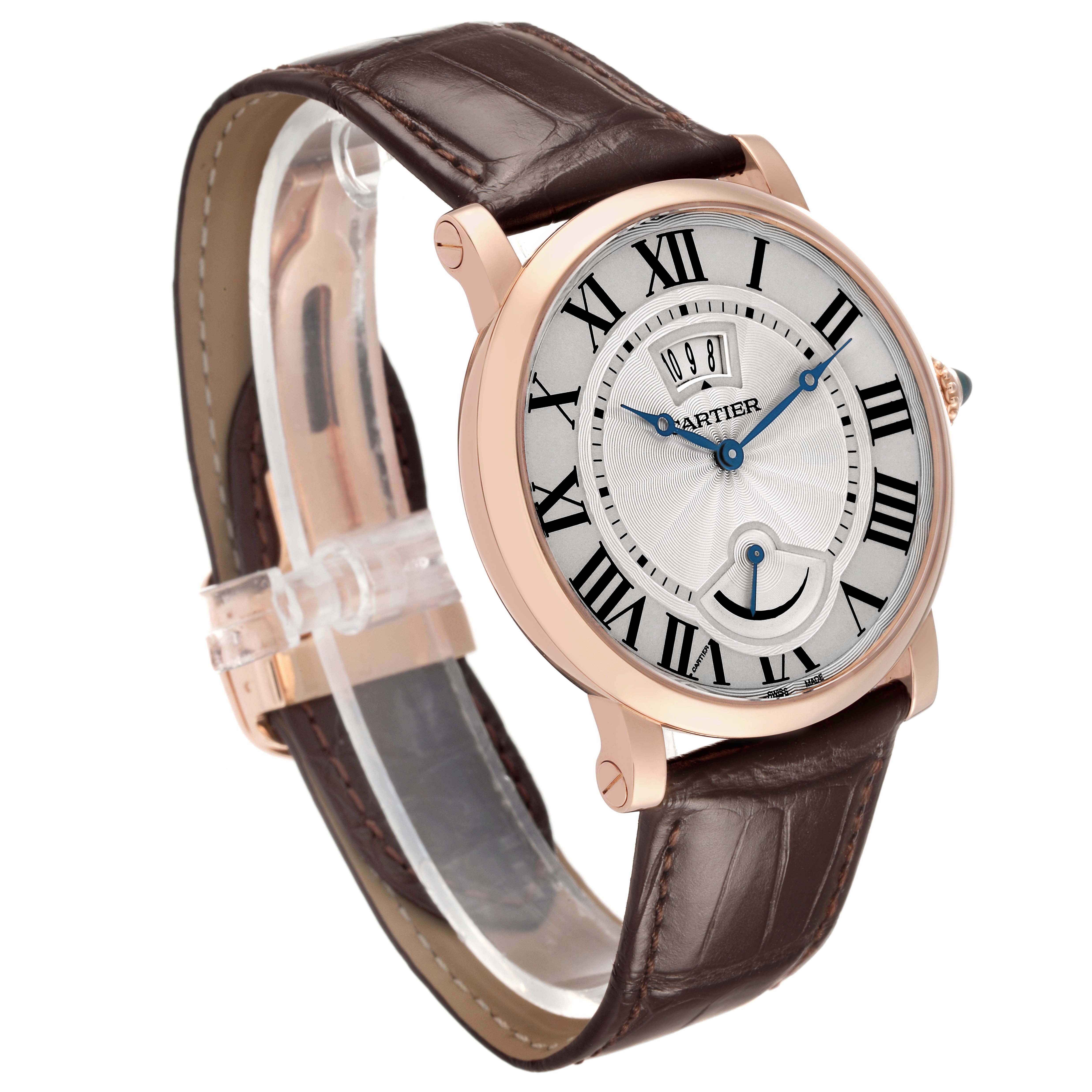 The image shows a Rotonde de Cartier watch at a three-quarter angle, highlighting its face, brown leather strap, and rose gold case.