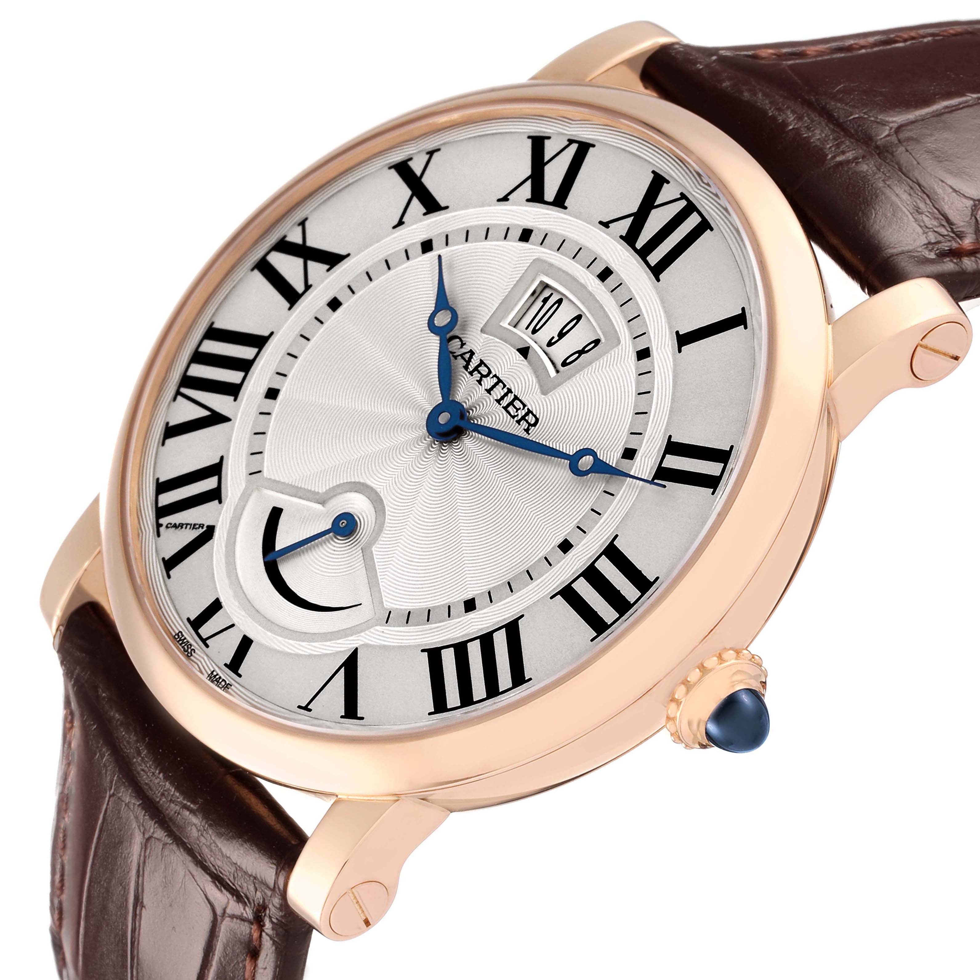 The Cartier Rotonde W1556252 Men's Rose Gold Silver Dial watch is shown at a three-quarter angle, highlighting the face, crown, and leather strap with Roman numerals and blue hands.