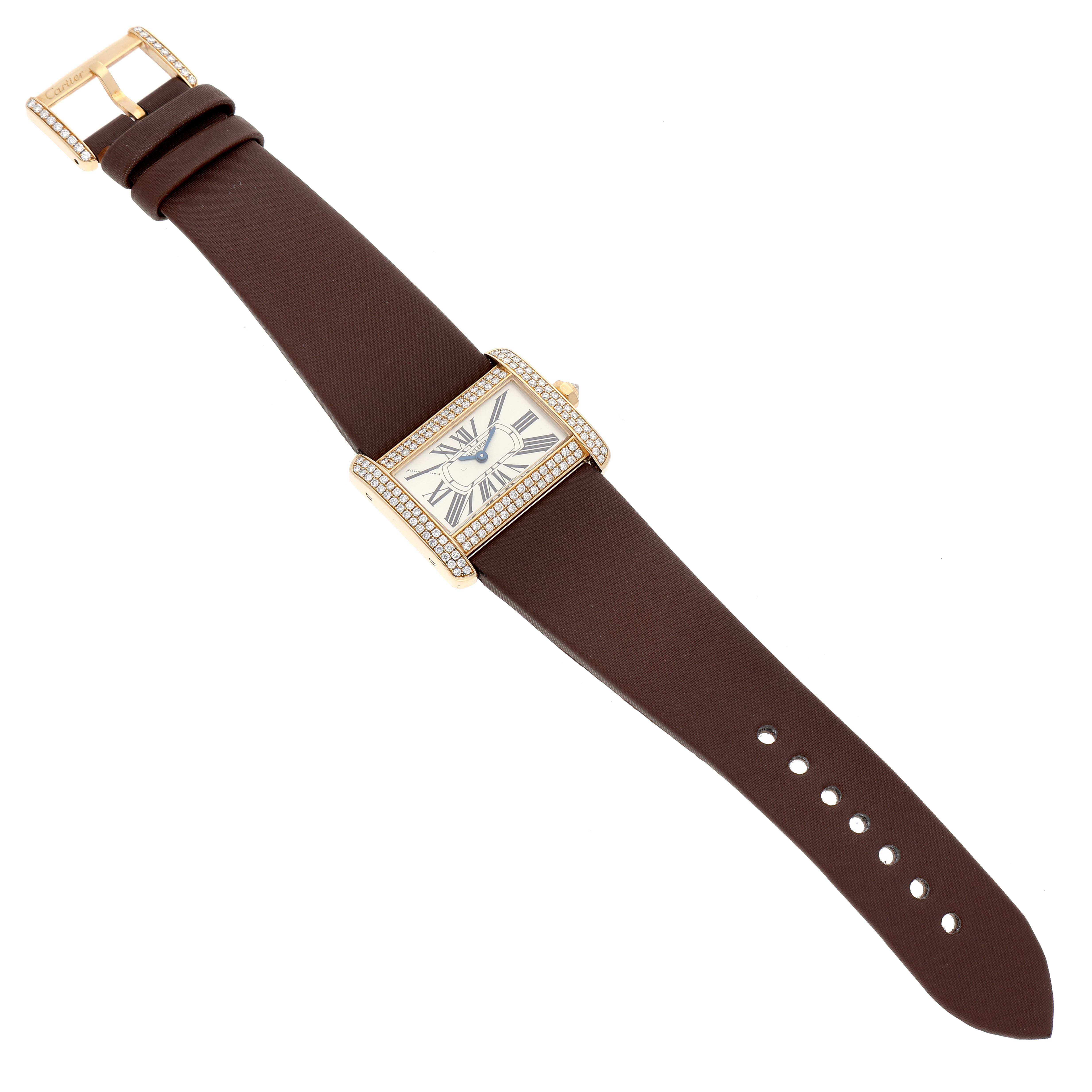 The Cartier Tank Divan WA301071 Women
s Yellow Gold Silver Dial WA301071 Women
s Yellow Gold Silver Dial watch is shown from a top-down angle, highlighting its face, strap, buckle, and diamond-studded bezel.