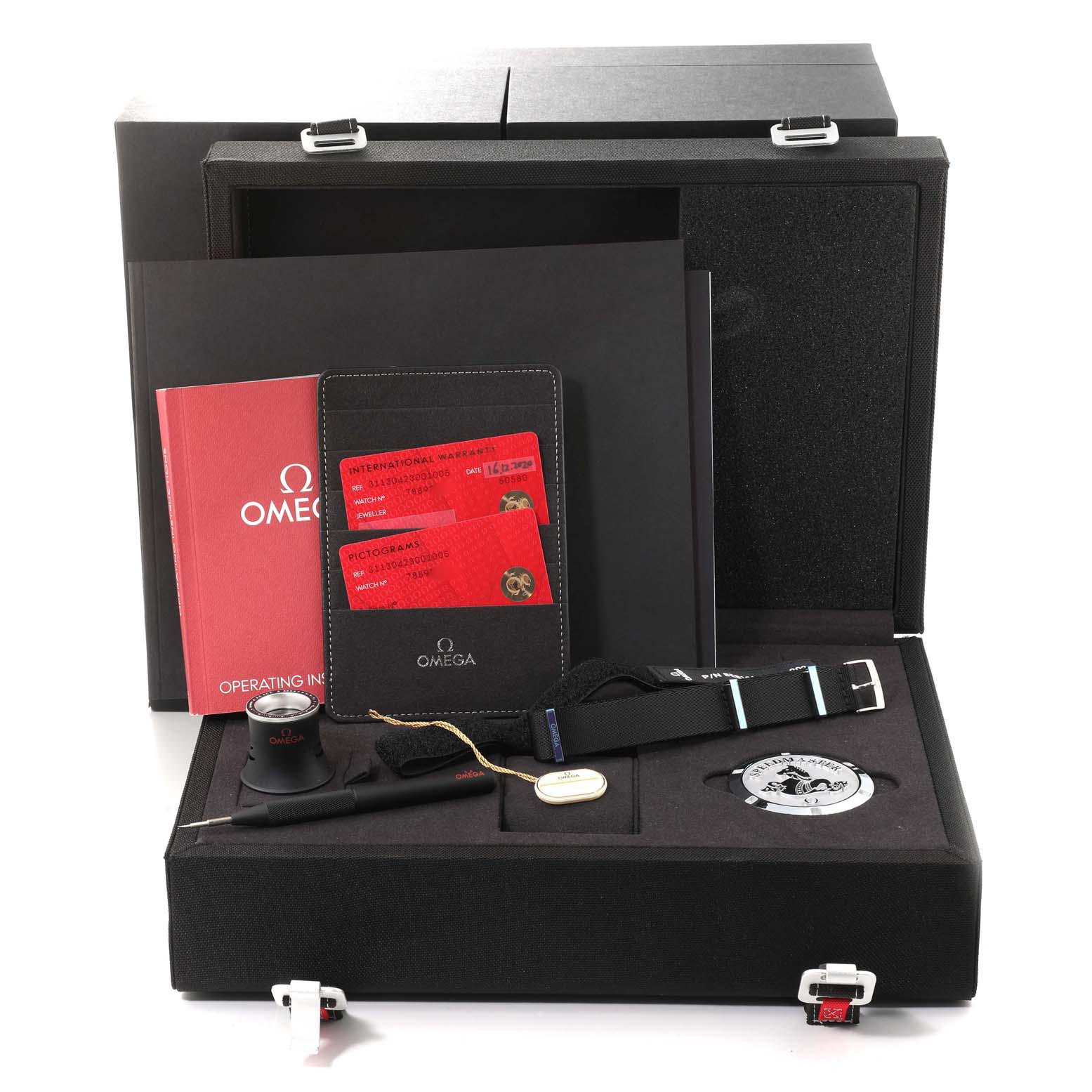 The image shows an opened box of Omega Speedmaster 311.30.42.30.01.005 Men
s Stainless Steel Black Dial 311.30.42.30.01.005 Men
s Stainless Steel Black Dial watch accessories, including documents, a loupe, a tool, and a spare strap.