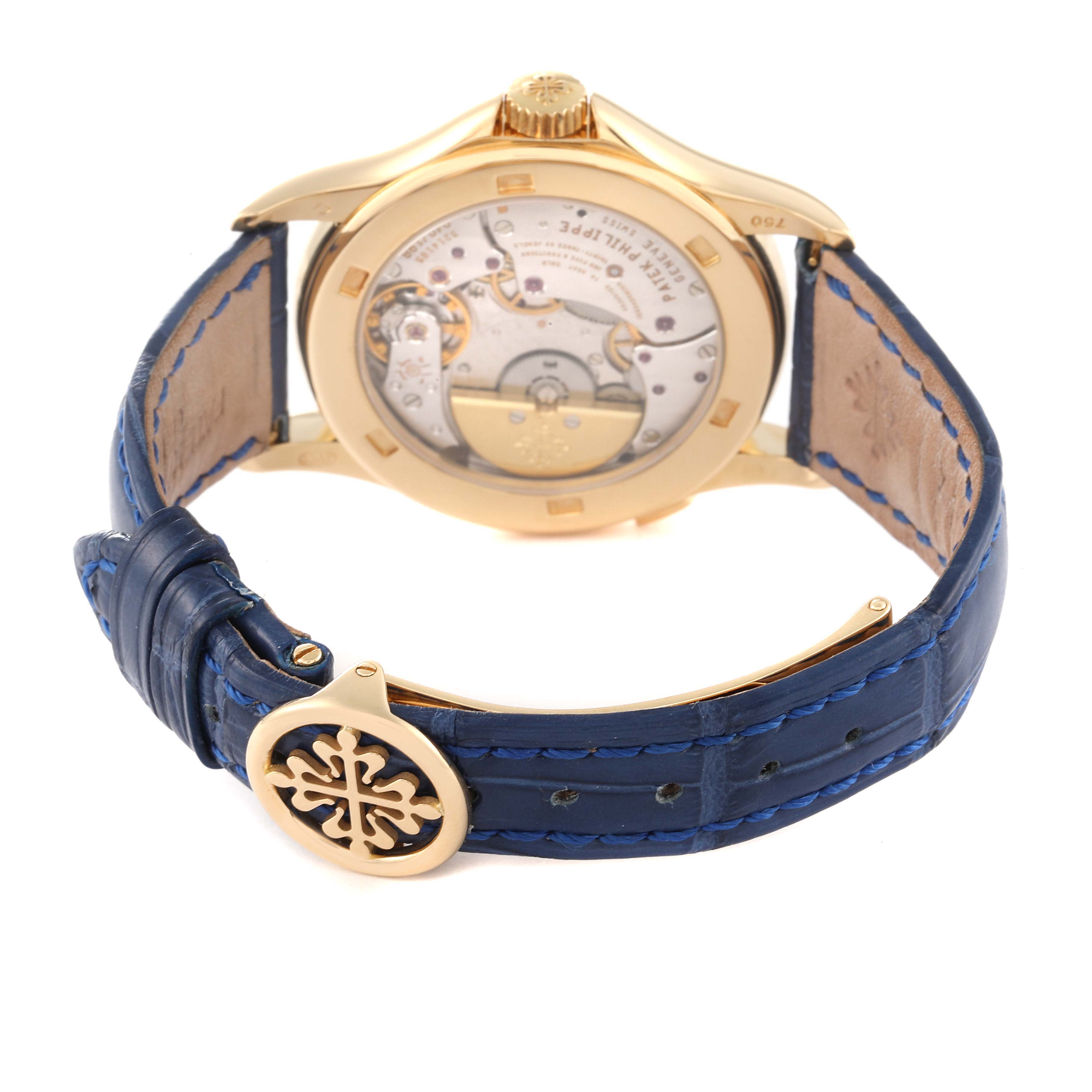 The image shows the back view of a Patek Philippe Complications 5110J Men's Yellow Gold Silver Dial 5110J Men's Yellow Gold Silver Dial watch, highlighting its movement and blue leather strap.