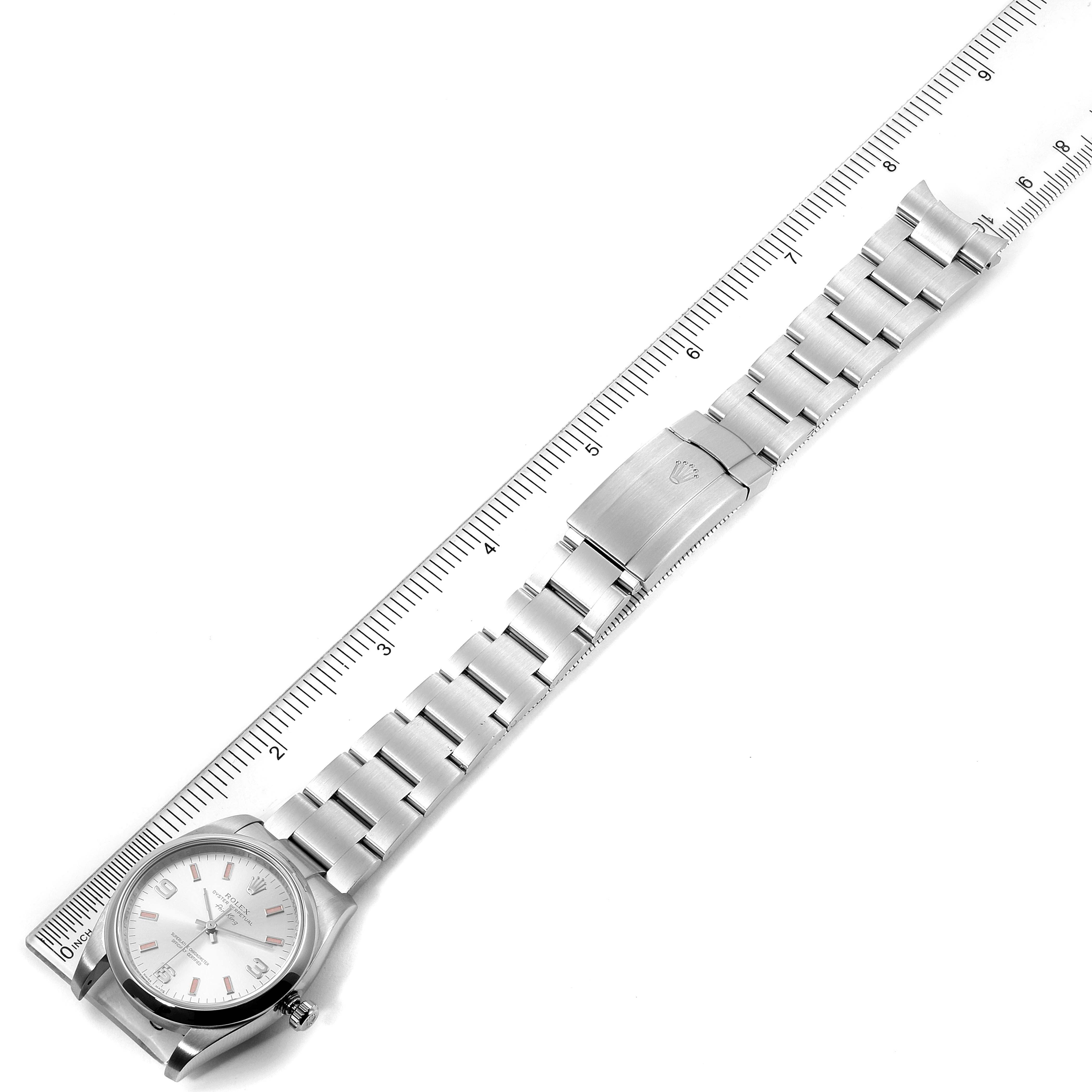 The image shows a top-down view of a Rolex Air-King 114200 Men's Stainless Steel Silver Dial 114200 Men's Stainless Steel Silver Dial watch with its stainless steel bracelet laid next to a ruler.